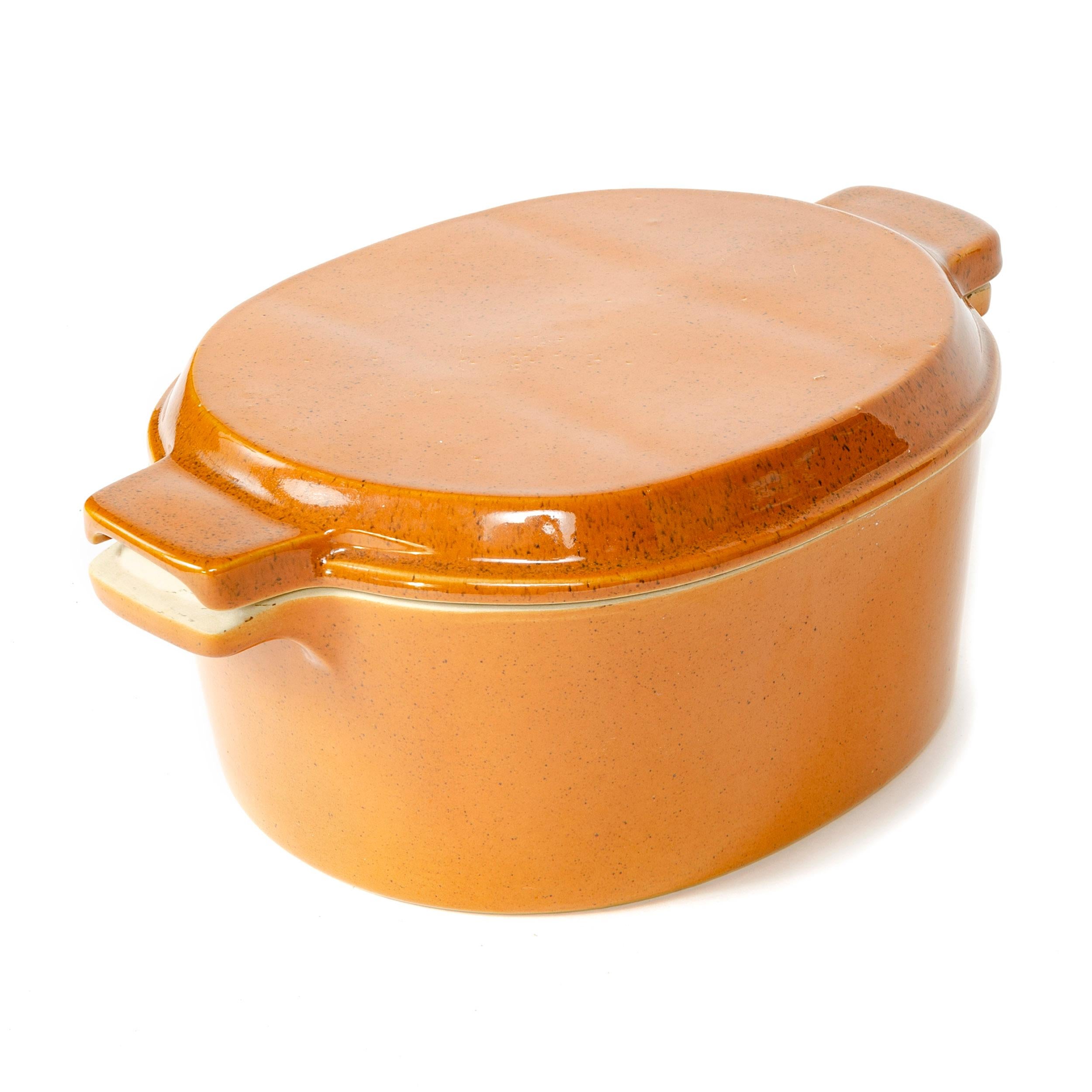 A substantial earthenware serving tureen with compartmentalized lid in a warm orange brown-flecked glossy glaze.