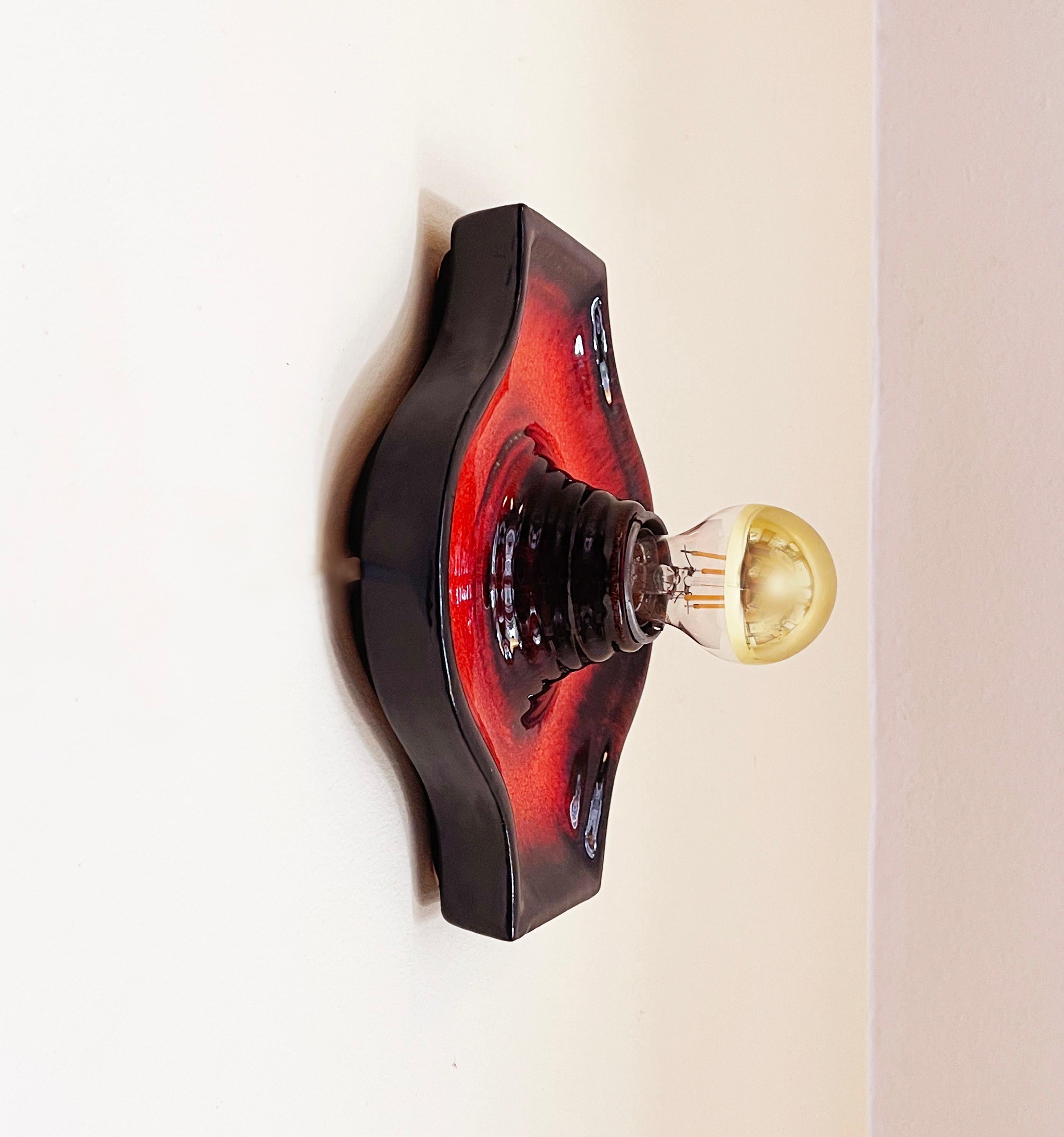 Fantastic sconce / wall light from Fat Lava ceramic by ''Hustadt Leuchten'' comes in a dark Brown, and vibrant red-orange glaze.
The chunky mid- century design favourite can be wall- or ceiling mounted.
The direction can vary and be either hardwired