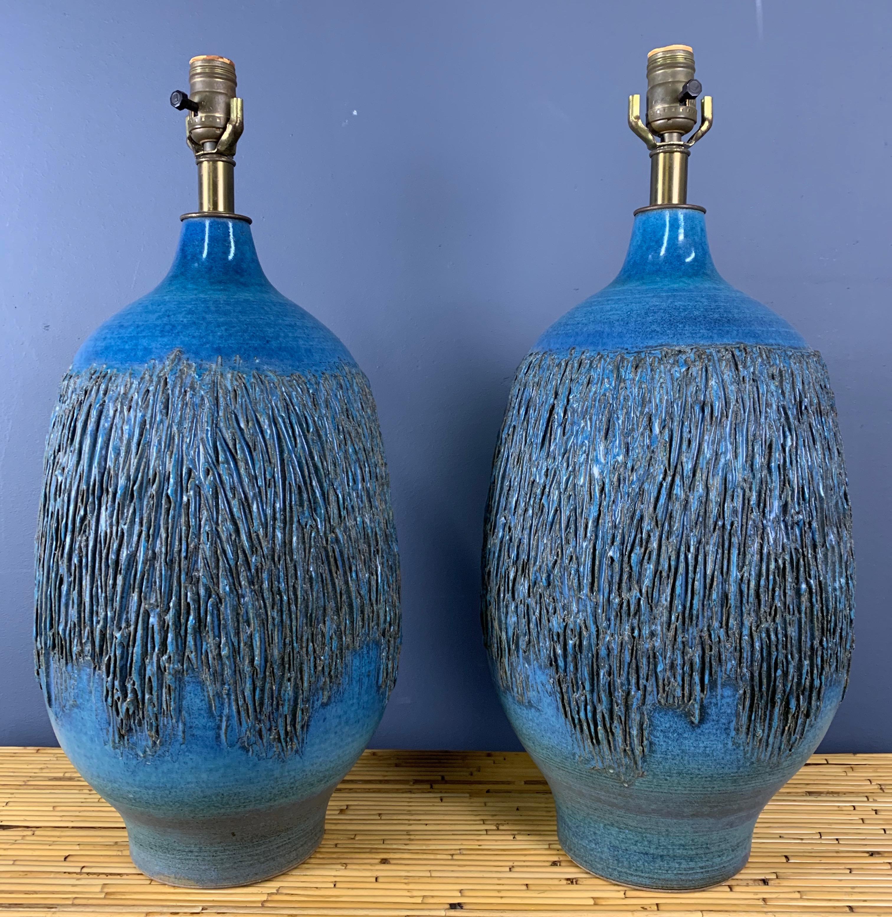 Incredibly beautiful ceramic lamps in a very rare blue green glaze by master ceramicist Lee Rosen. These lamps have an intricate, brutalist raised design and are both signed.

The Design Technics Studio operated in the middle of the 20th century and