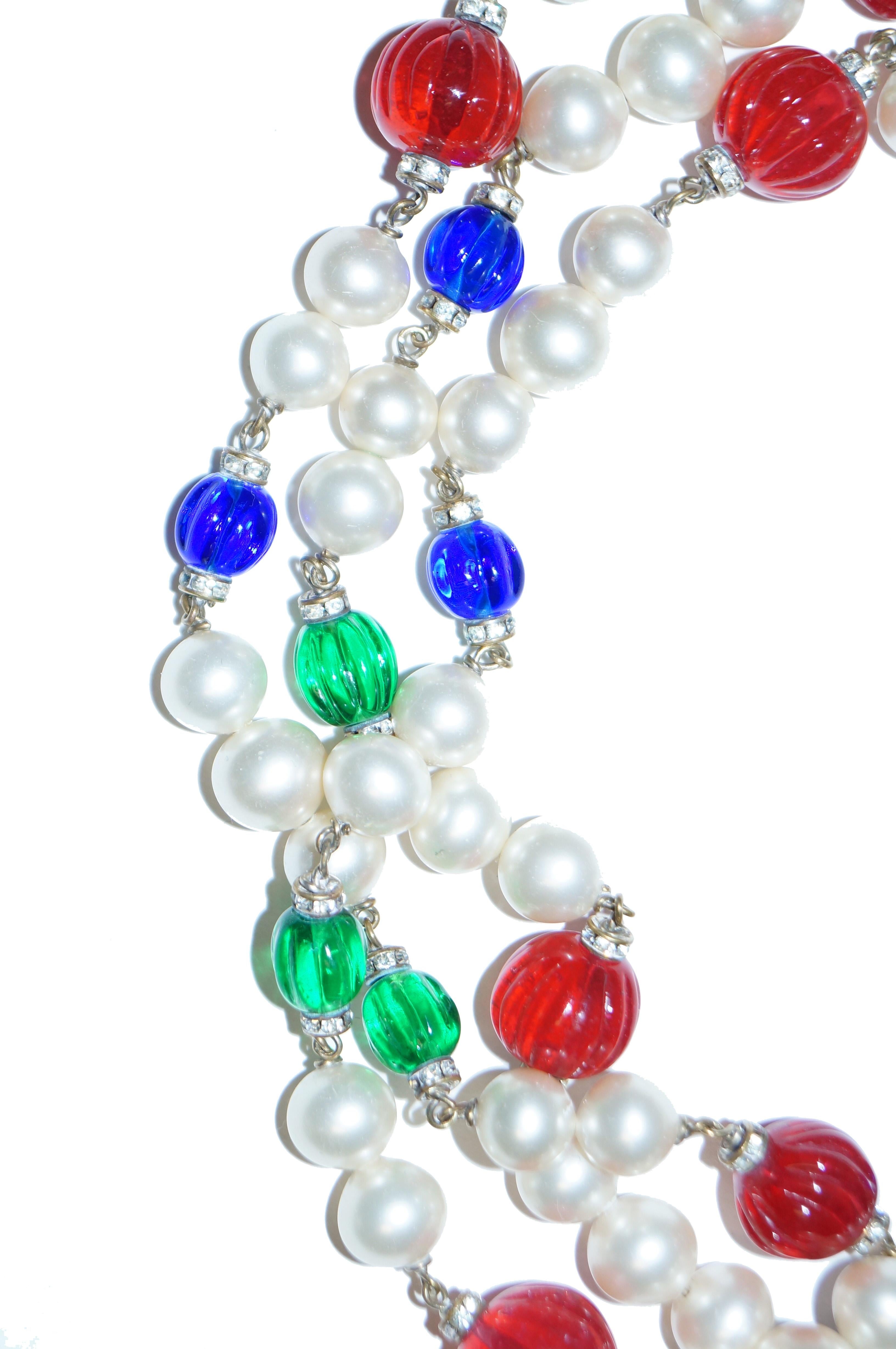 Opera length faux pearl and pate de verre Gripoix glass necklace. This Chanel piece features a pearl strand of beads with brilliant translucent candy - like glass beads in poppy red, royal blue, and kelly green. 

The necklace is unmarked as were