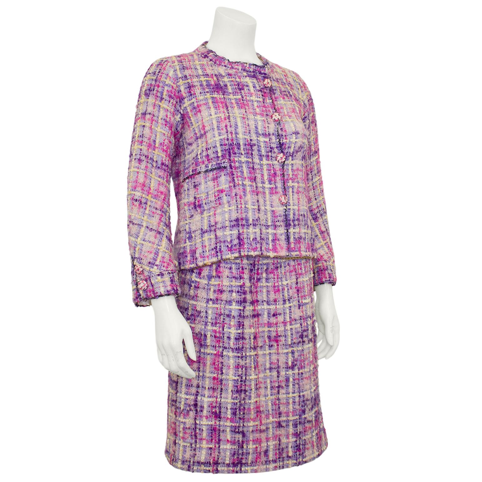 A glorious Chanel Haute Couture jacket and dress from the 1960s. Crafted from beautiful pink, purple and cream tweed with thin black trim. Collarless jacket with a single patch pocket at the waist on the right side when wearing. Lovely abstract