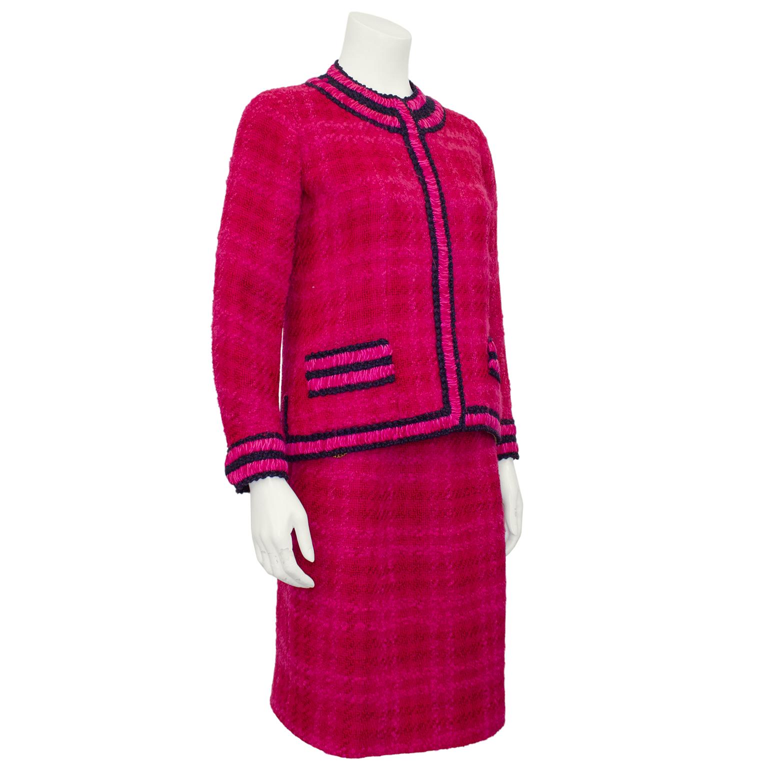 Magnificent Chanel Haute Couture skirt suit from the 1960s. From the estate of an avid Chanel Couture collector, this suit is truly special. Thick wool magenta with a faint fuchsia all over plaid. The jacket is trimmed in navy blue and fuchsia.