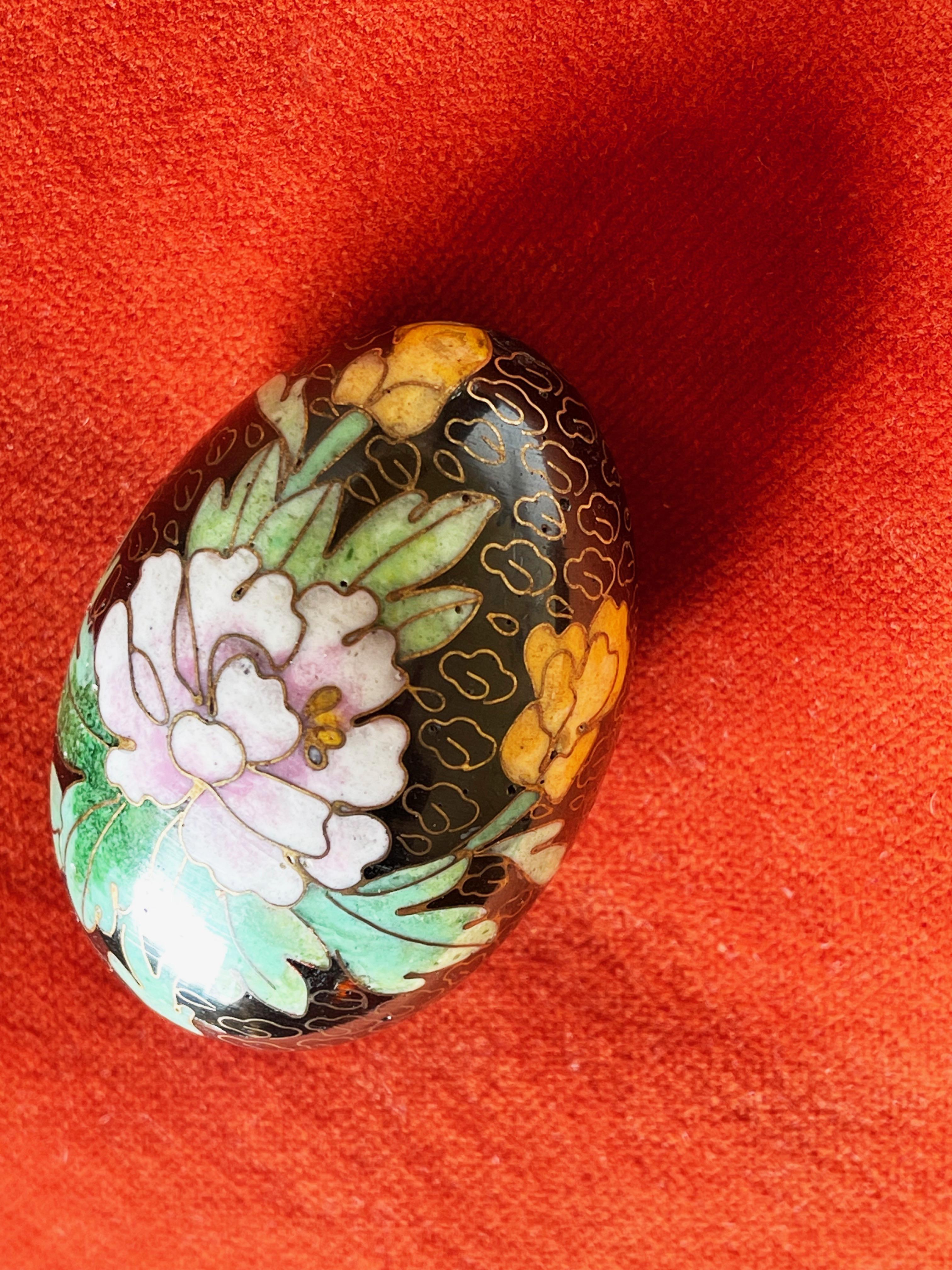 Intricately detailed Cloisonné egg of ''regular'' size in black, pink, golden yellow & greens.
The metal filigree in brass: beautifully detailed with a butterfly, chrysanthemum in a mild pink and other flowers with lush leaves.
The bottom comes with