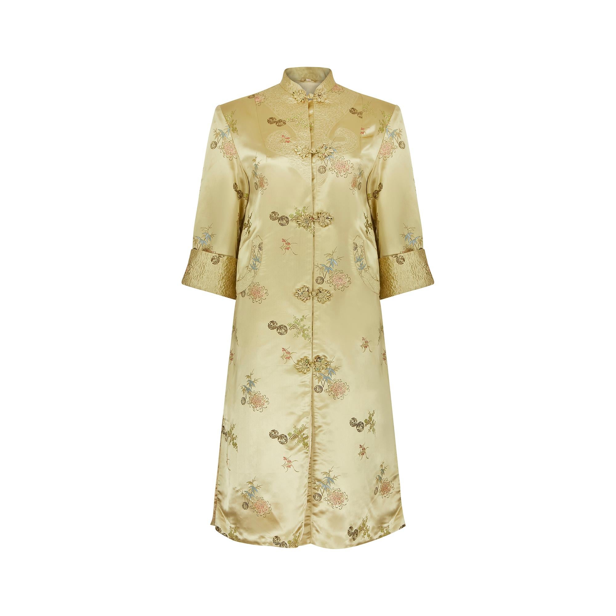1960s Chinese dress coat which was made for the export market throughout the 50s and 60s in Shanghai.  In a lovely burnished gold manmade satin jacquard fabric with a neat floral arrangement of honeysuckle, bamboo and cherry blossom in soft tones of