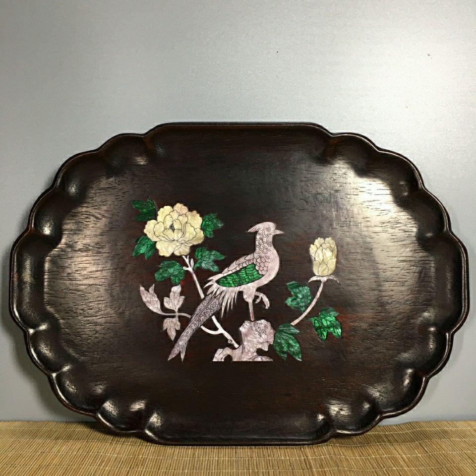 Add a touch of classic Chinese artistry to your collection with this exquisite 1960s Chinese Wood Plate with Shell Birds and Flowers. This vintage plate is handcrafted from fine wood and adorned with intricate mother-of-pearl inlays, depicting