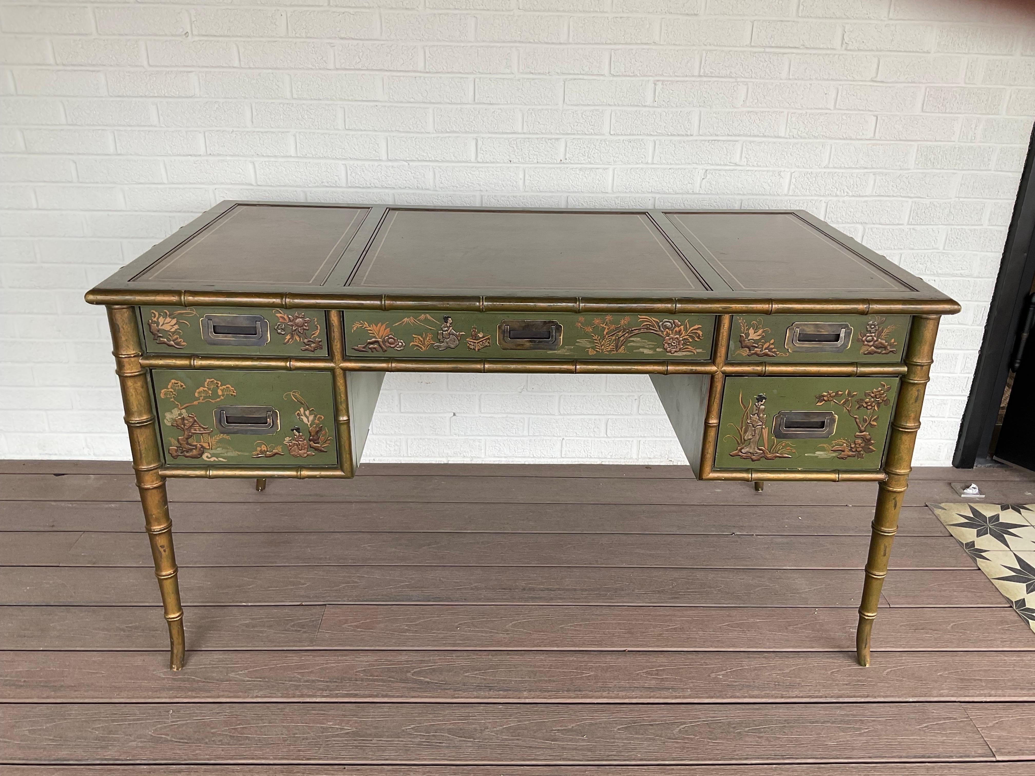 Extraordinary vintage chinoiserie desk from Drexel is extremely rare and fresh from a Palm Beach estate. Gold faux bamboo legs and trim detail surround intricate hand painted scenes from the orient over an intoxicating green lacquered background and