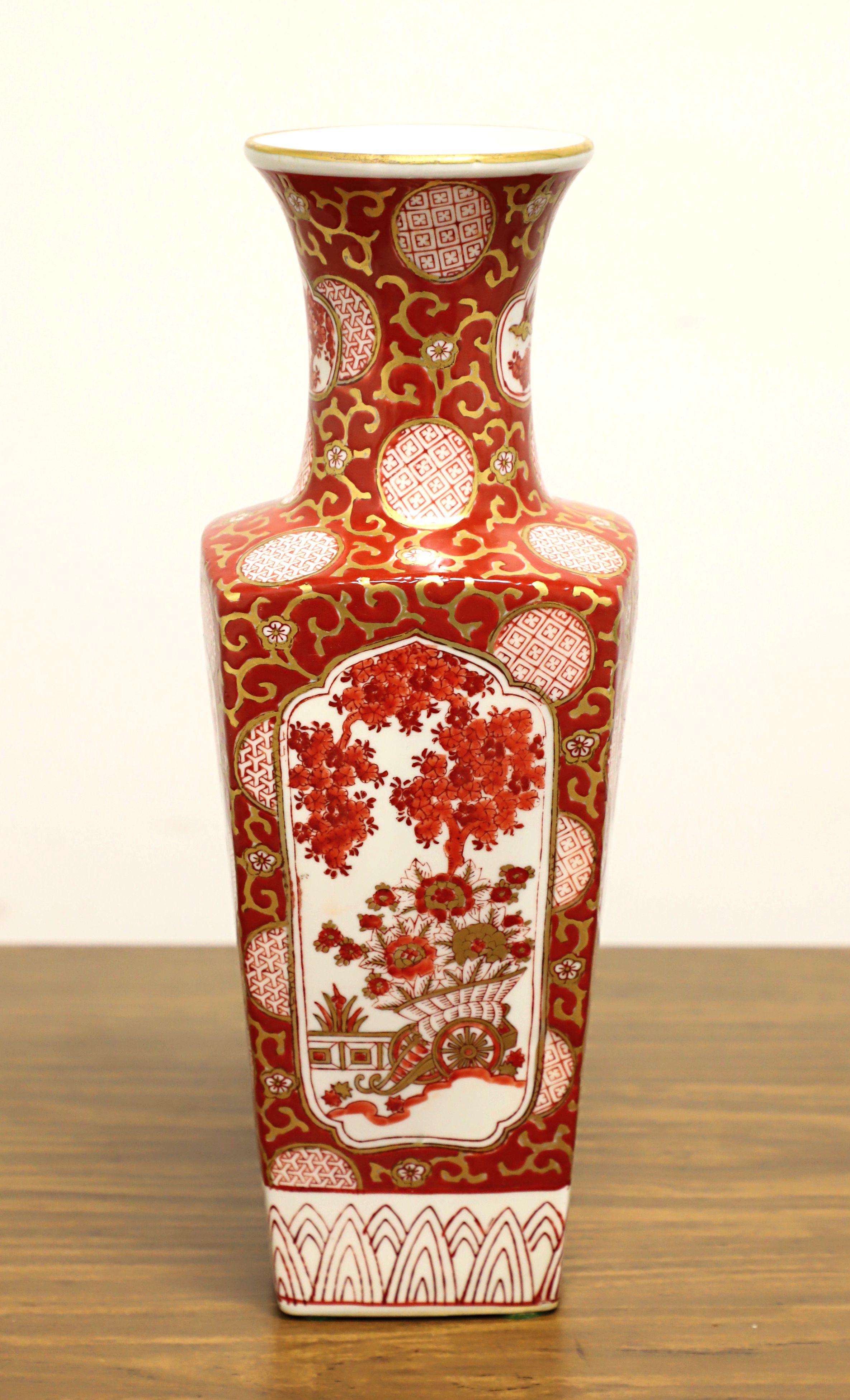 An Asian Chinoiserie style table vase, unbranded. Hand painted porcelain with a Chinoiserie design of foliate, floral & geometric shapes in shades of white, red & salmon colors with gold trim, and a tapered square urn shape with round neck. Likely