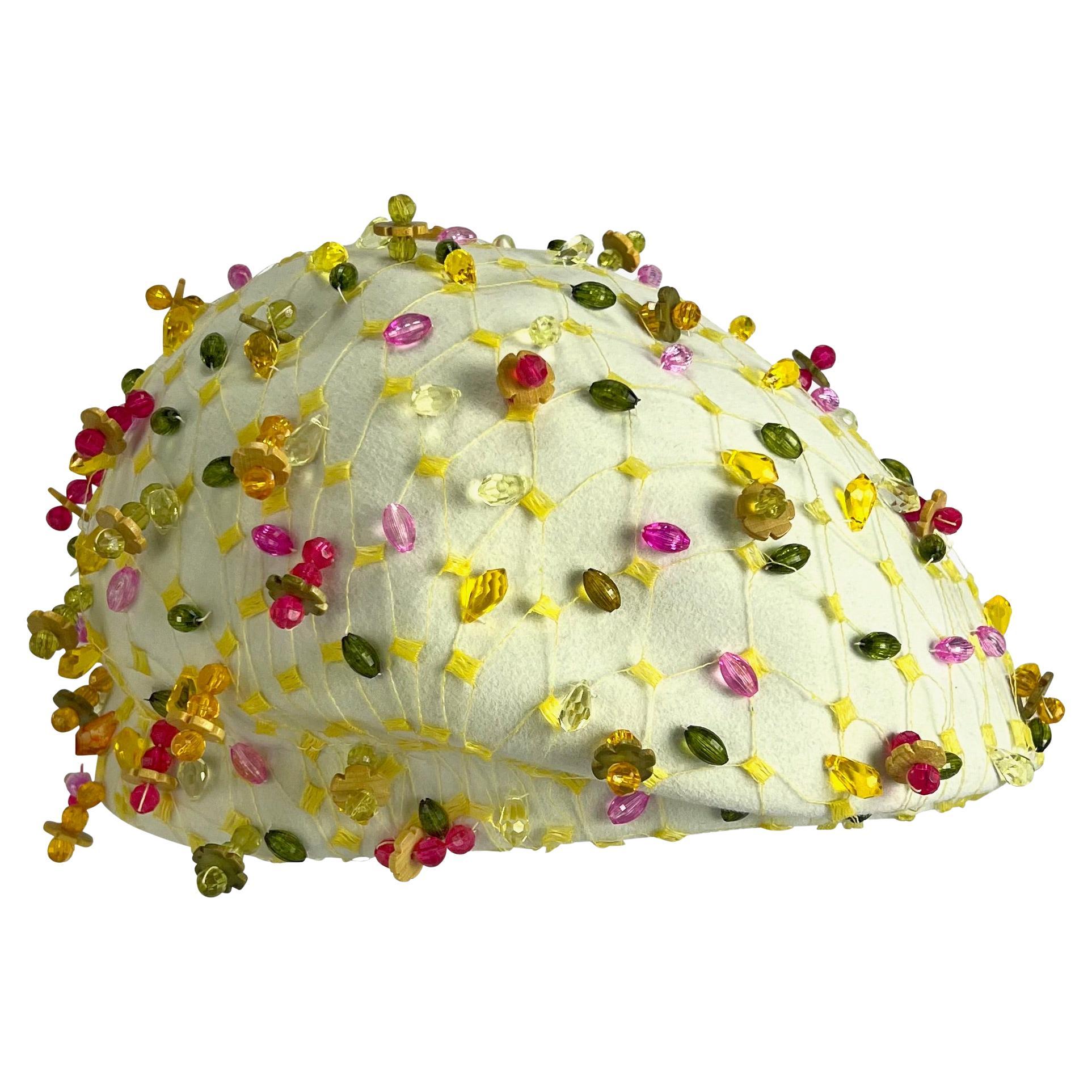 Presenting a fabulous off-white vintage Christian Dior webbed and beaded hat. From the 1960s, this hat is covered in a vibrant yellow net and is embellished with a variety of beautiful multicolor beads. 

Approximate Measurements: 
Height: