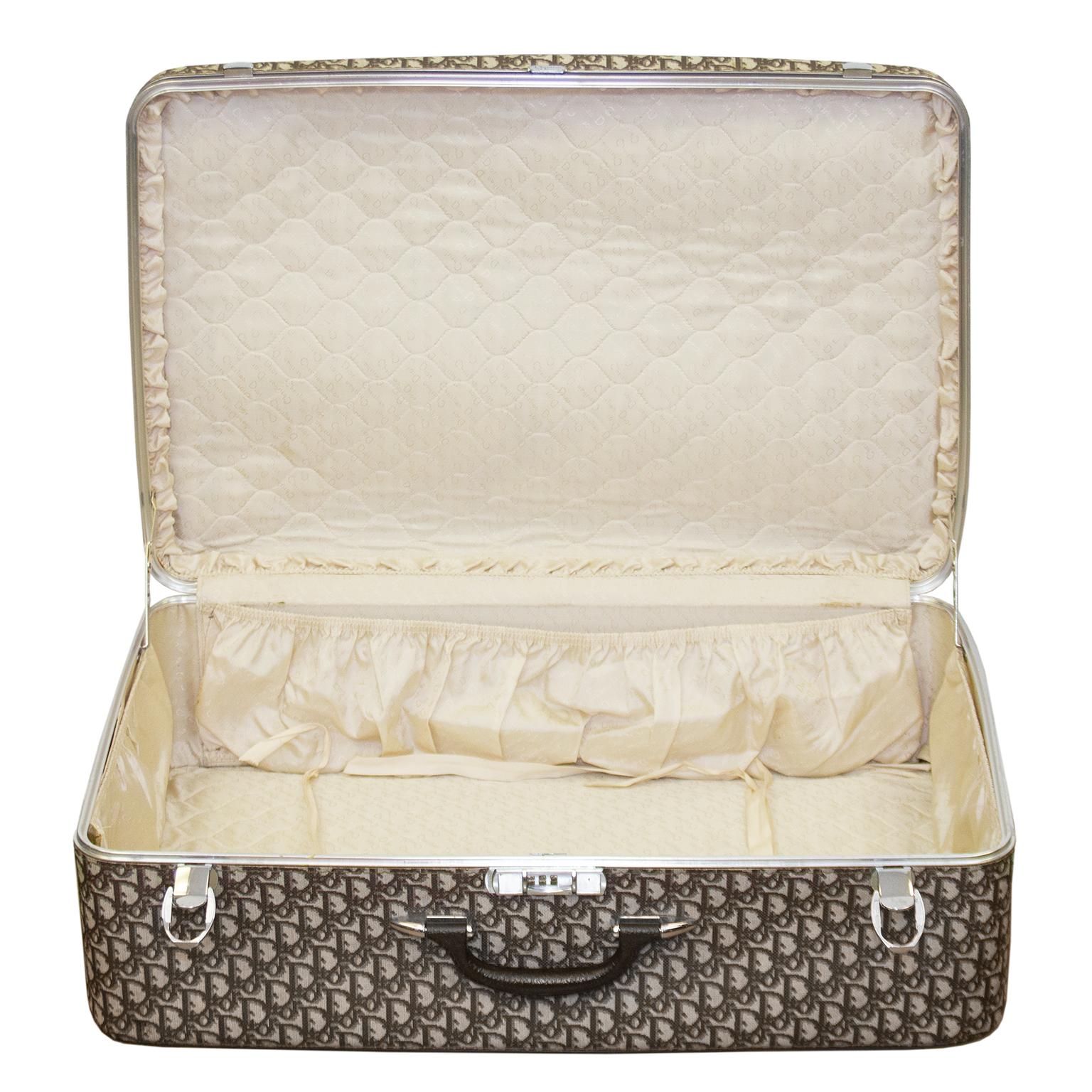 Travel in glamorous style with this Christian Dior hard frame suitcase from the 1960s. From a time when travelling was an occasion worth dressing for, this large suitcase is a durable textured logo vinyl with an all over brown and tan Dior monogram