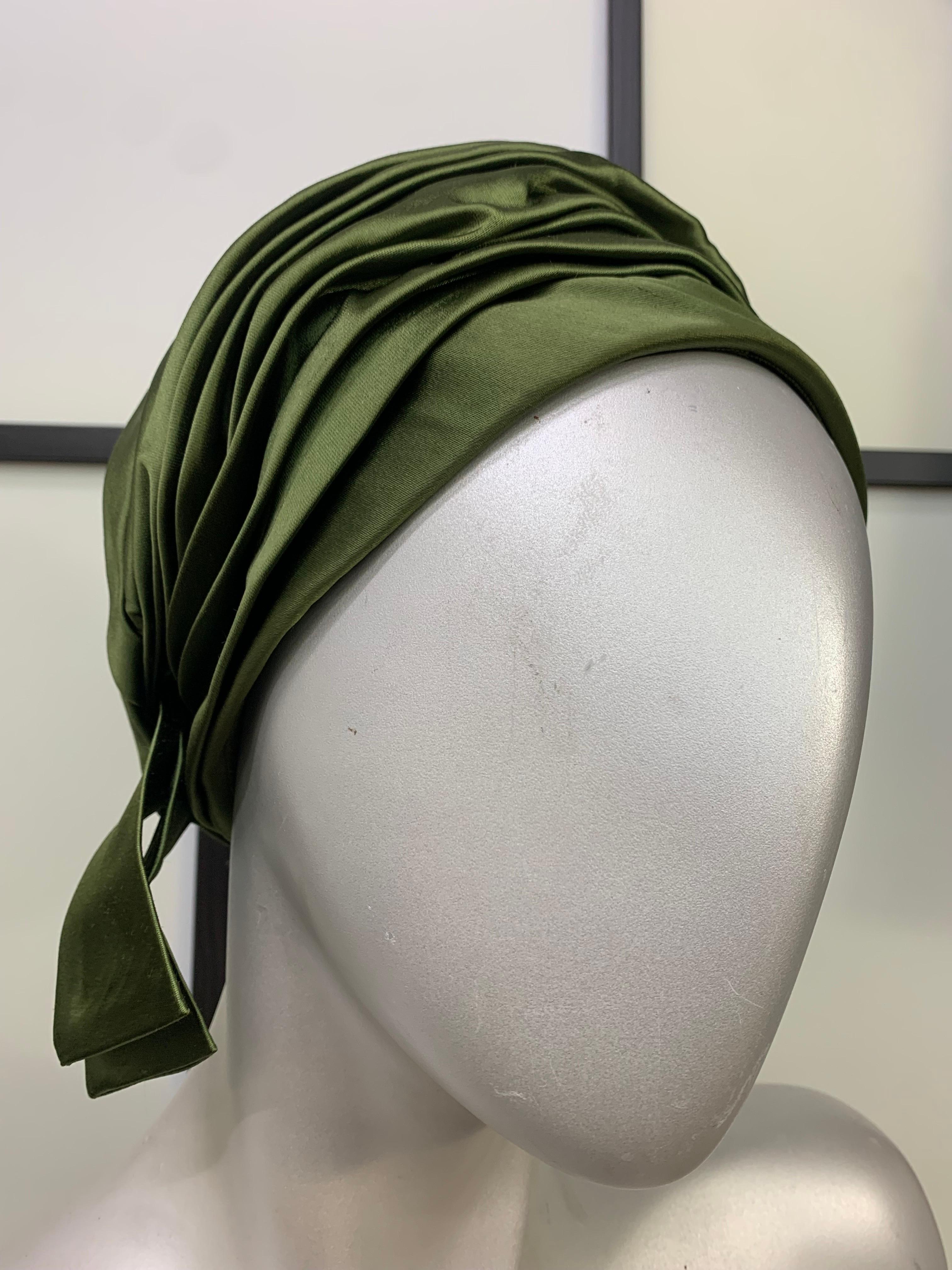 A fabulously louche 1960s Christian Dior by Marc Bohan, sage green silk satin turban hat:  Pleated sage green satin turban hat is styled to one side for personality!   Worn with a tailored look, this is especially chic. Size 22.