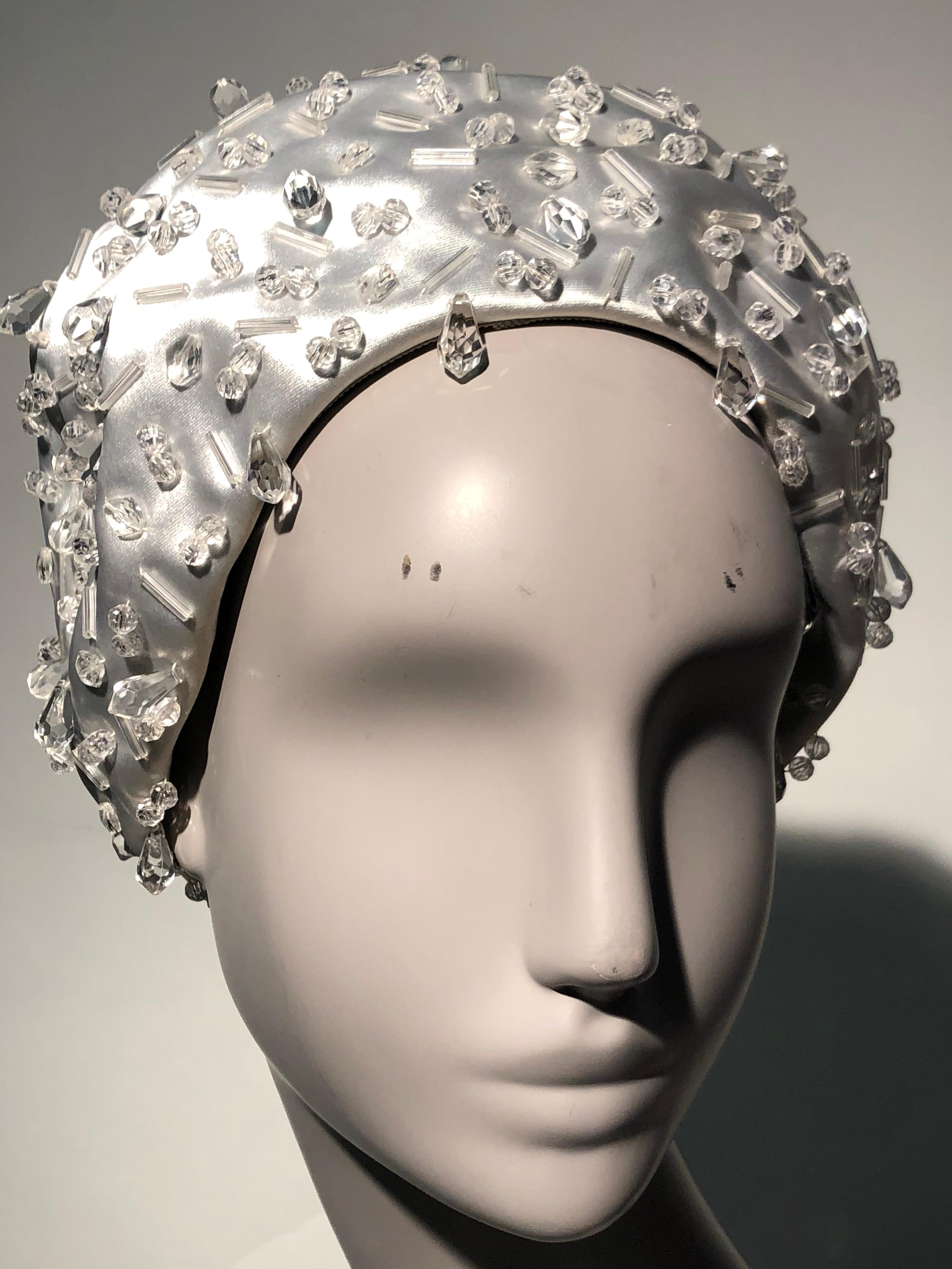 An unusual and beautiful 1960s Christian Dior petite bubble hat in silvery-white silk satin and glittery beadwork. Worn like a crown, it's a regal look for a wedding!