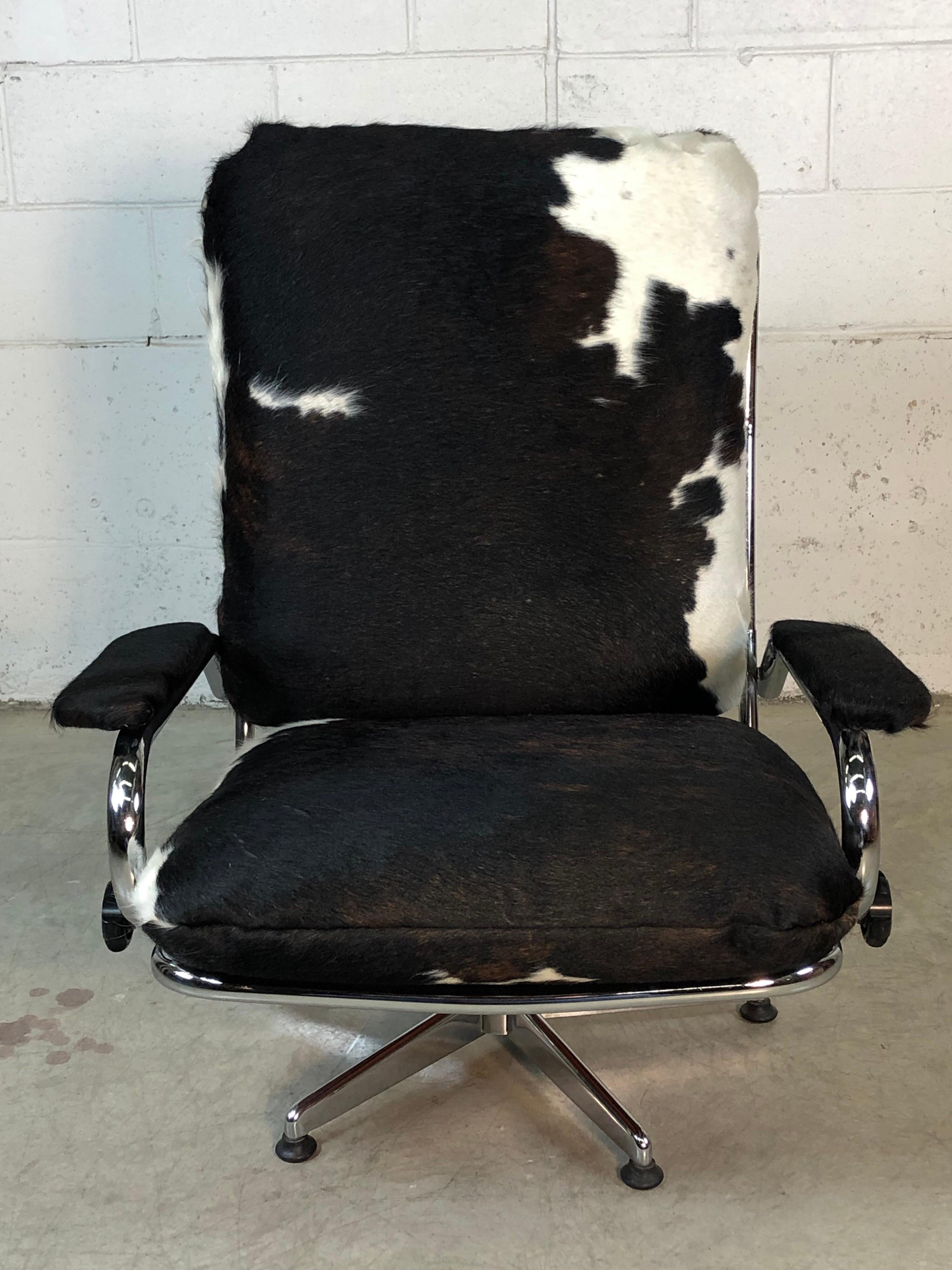 Mid-Century Modern 1960s chrome reclining lounge chair with new cowhide fabric. This chair is fully adjustable up and back and fully swivels around. The original straps are tight and in very good condition. The chrome is excellent with no scratches