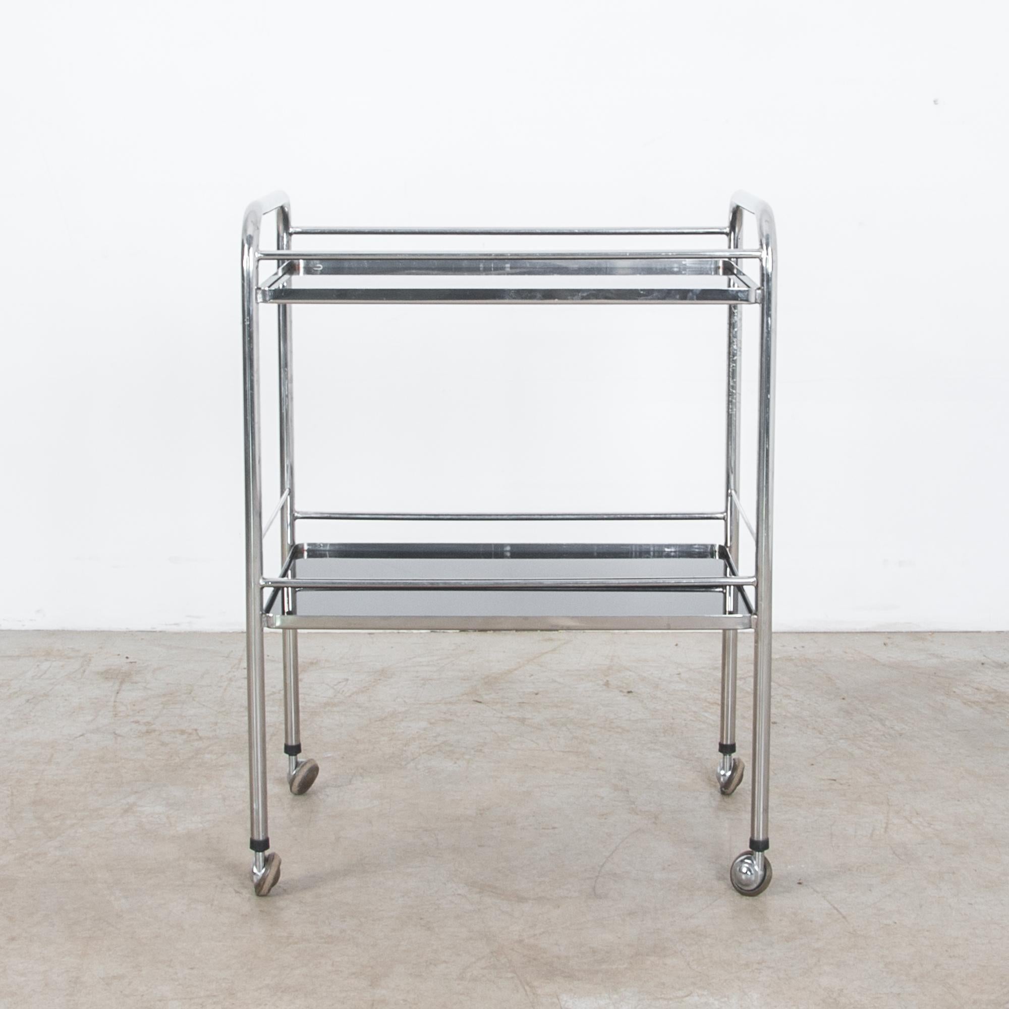 From France, circa 1960, a sleek rolling cart in modern style. Made from tubular steel and glass, this cart utilizes clean and modern materials, with an equally crisp composition. Straight lines and rounded edges give a proper geometric appearance