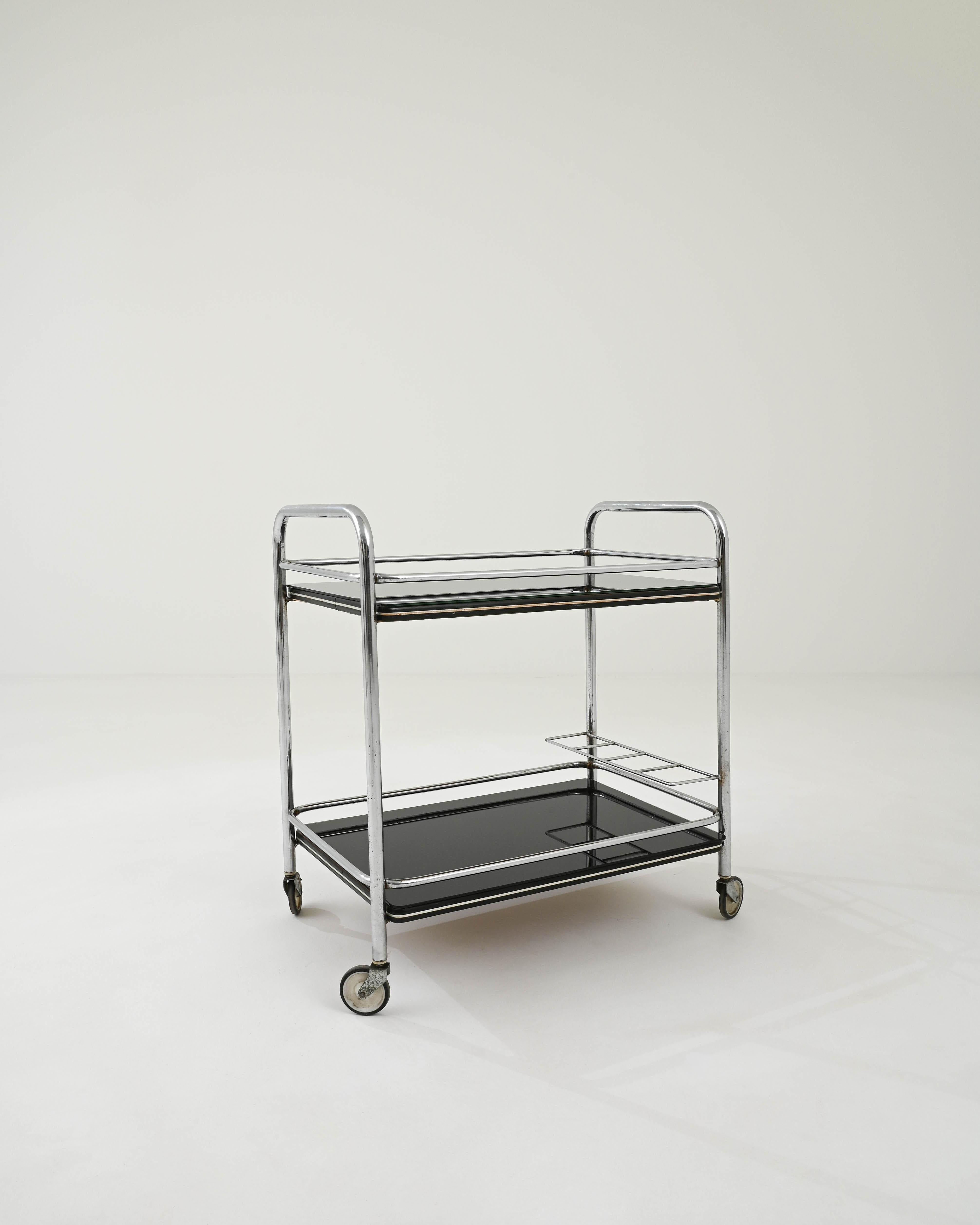 From France, circa 1960, a sleek rolling cart in modern style. Made from tubular steel and glass, this cart utilizes clean and modern materials, with an equally crisp composition. Straight lines and rounded edges give a proper geometric appearance