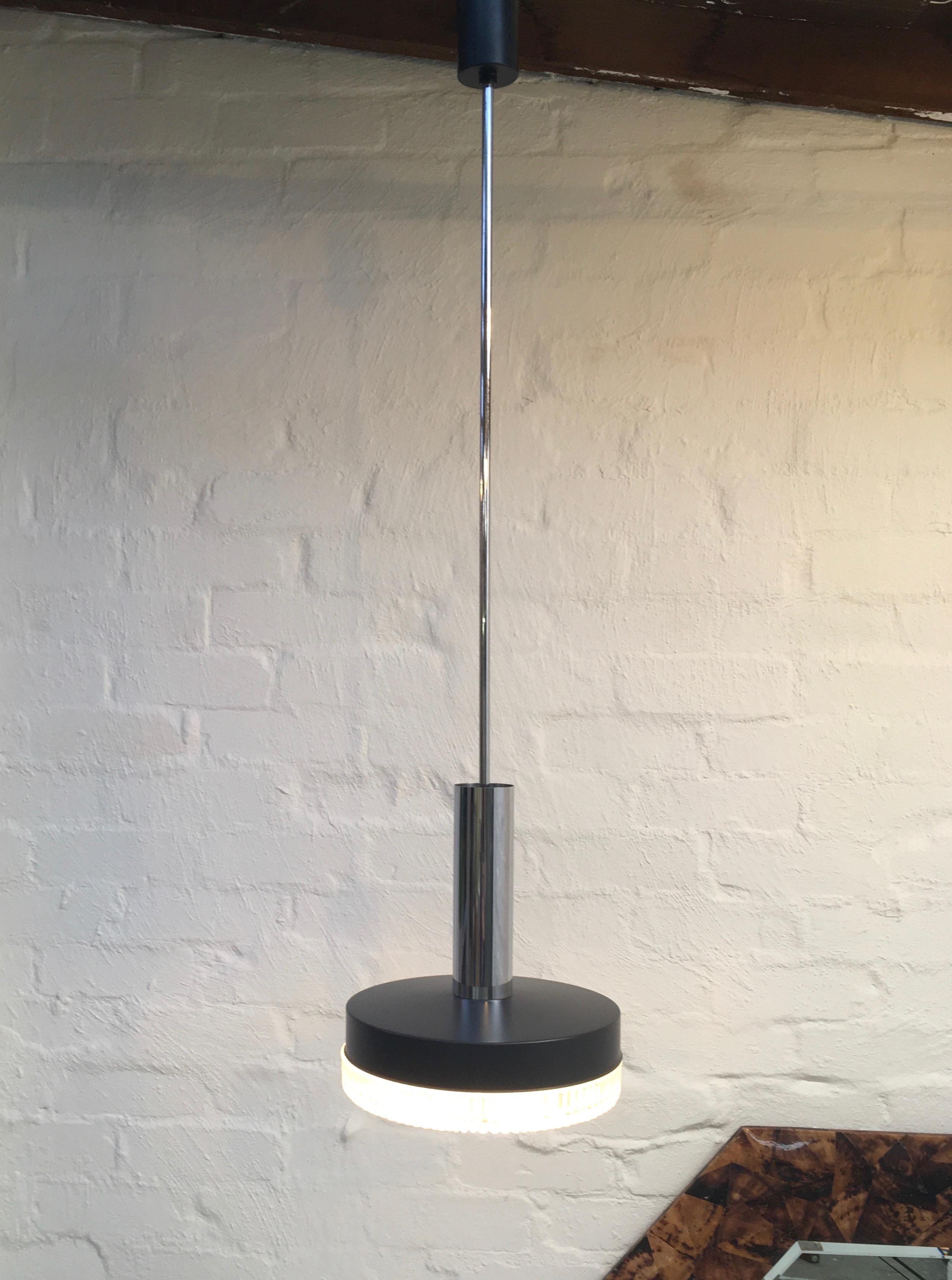 An elegant, long-stemmed pendant light in restrained modernist midcentury style. Several producers made lights like this: Stilnovo in Italy; Orrefors in Sweden; Lyfa in Denmark; RAAK in the Netherlands. 

We are plumbing for RAAK or Lyfa on this