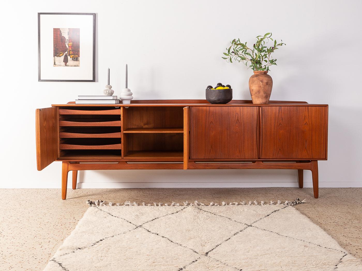 Classic sideboard from the 1960s by Svend Åge Madsen for Knudsen & Søn. Corpus in teak veneer with four doors, three shelves, four internal drawers and slanted feet.

Quality Features:
 accomplished design: perfect proportions and visible