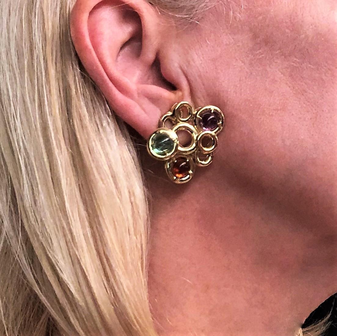 Made in Italy, these lovely 1960s clip on earrings are made of 18K Yellow Gold circles set  with six cabochon semi precious stones, Aquamarine, Amethyst and Citrine. The soft colors are wonderful to be worn with your spring wardrobe. They measure 1 