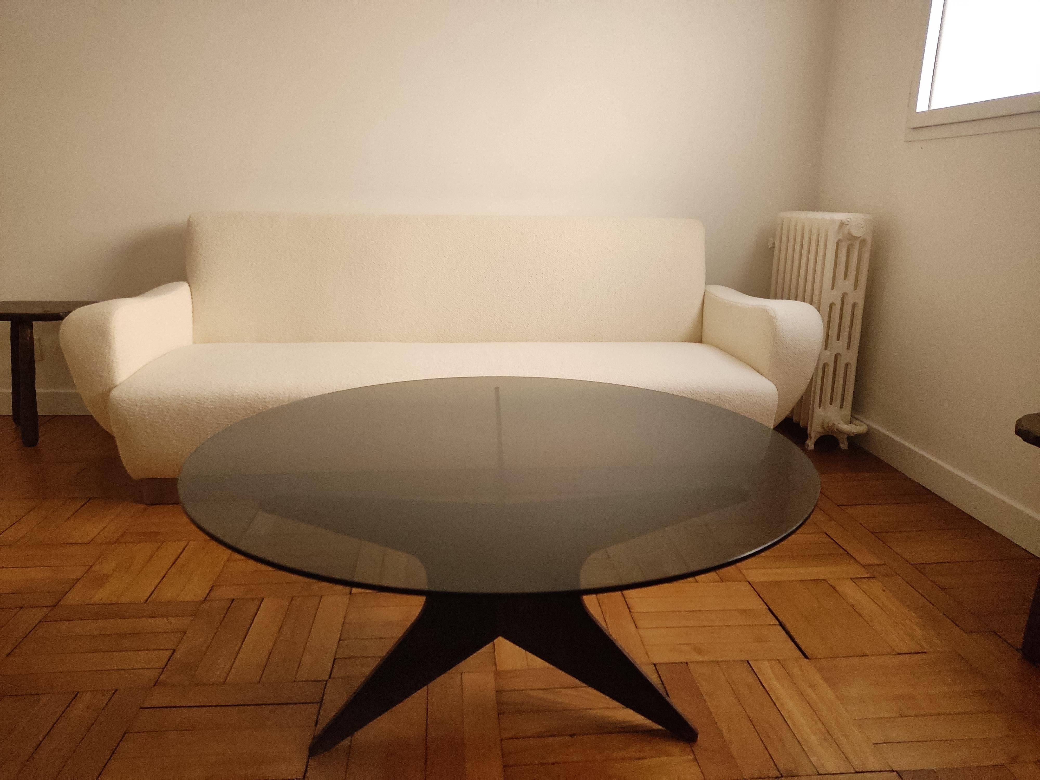 table basse des années 1960 composée d'une base en forme d'étoile en fer patiné nuageux et d'un plateau en verre circulaire fumé.