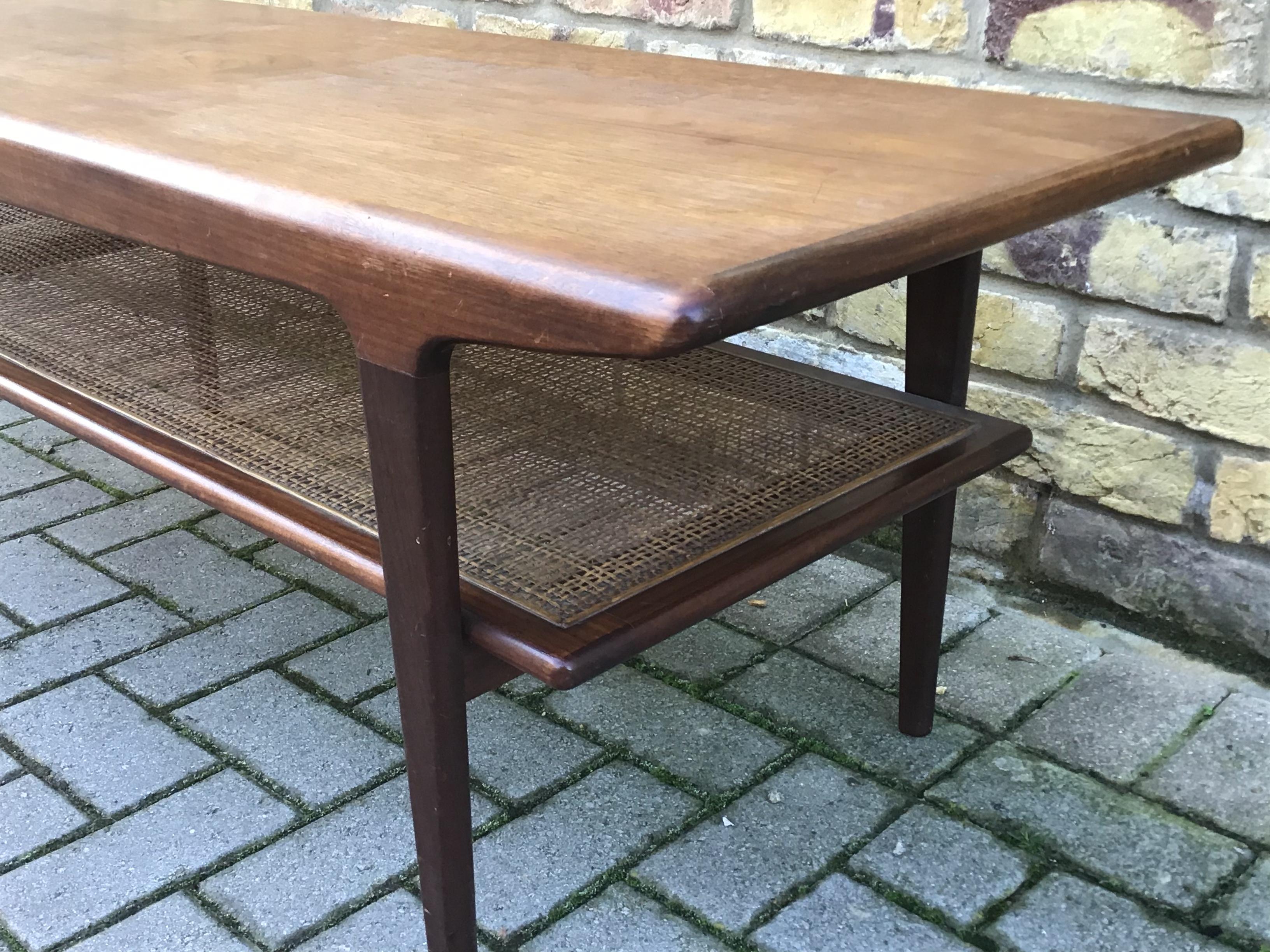 Well crafted teak coffee table with rattan shelving rounded edges
circa 1960s John Herbert.