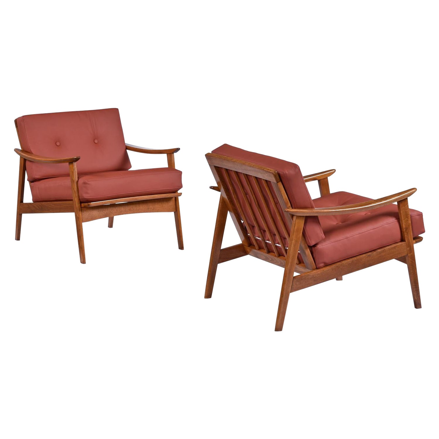 Handsome pair of solid beech wood Mid-Century Modern armchairs made in Scandinavia. These classic, timeless armchairs have been refinished and updated with all new top grain burgundy-cognac leather upholstery and handsome button tufting. Tailored