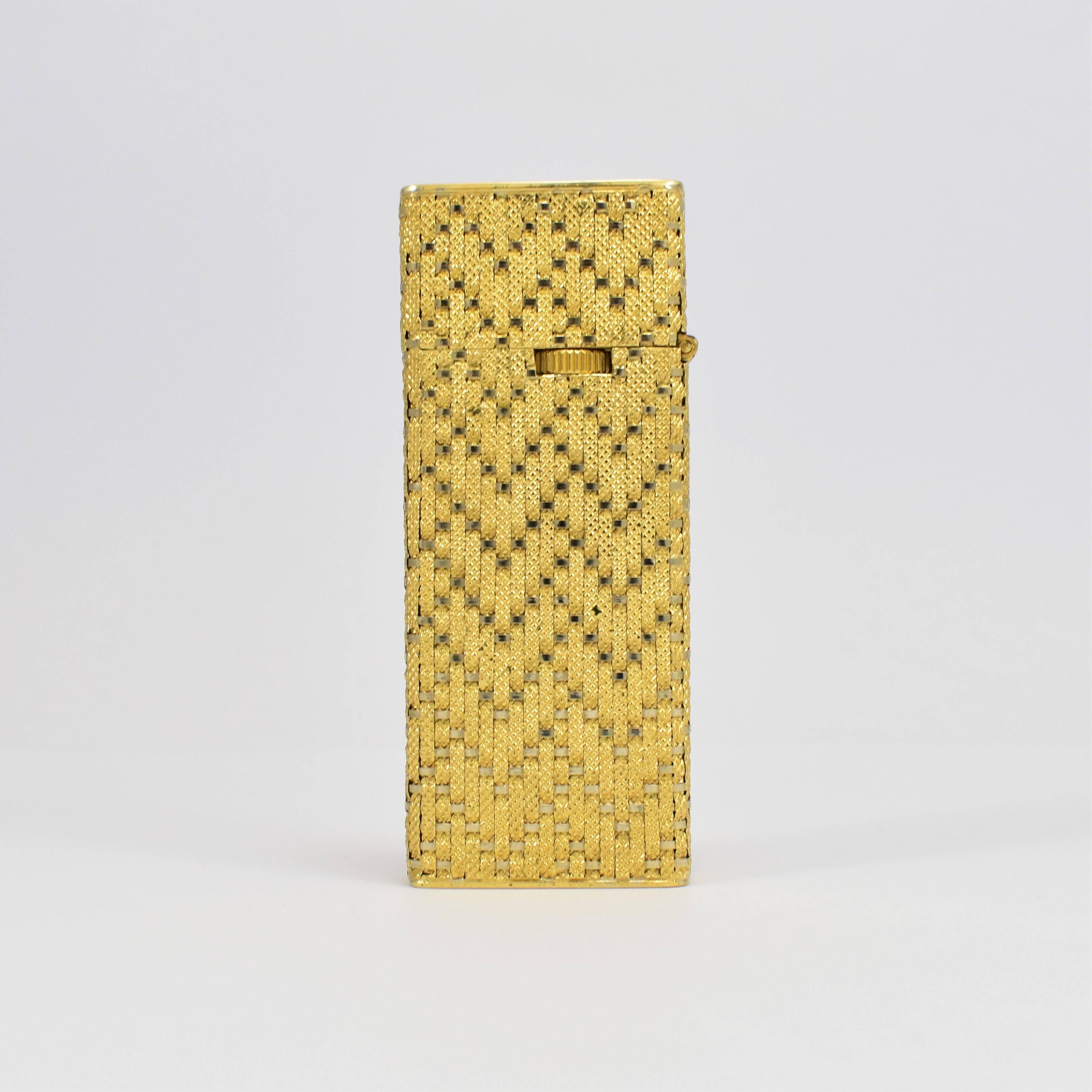This 1960s lighter of immaculate craftsmanship in rendered incased in woven (tested as) 18-karat yellow gold, weighing 48.25 grams. The artistic basket weave pattern on both sides creates an ornate, stylish design. This collectible piece functions