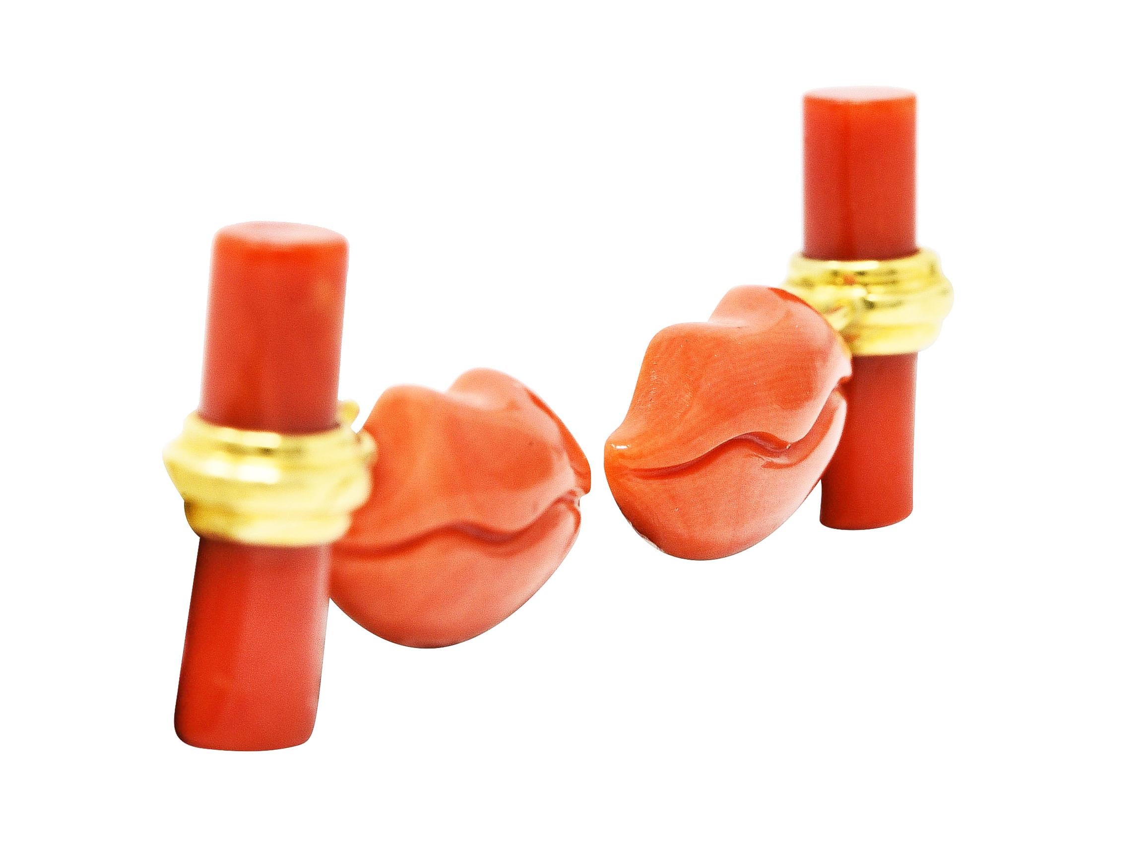 Link style cufflinks terminate as carved coral lips and cylinders at each end. Opaque light to medium reddish-orange with white mottling. With grooved gold loop around cylindrical coral form. Tested as 18 karat gold. Circa: 1960's. Total length: 1
