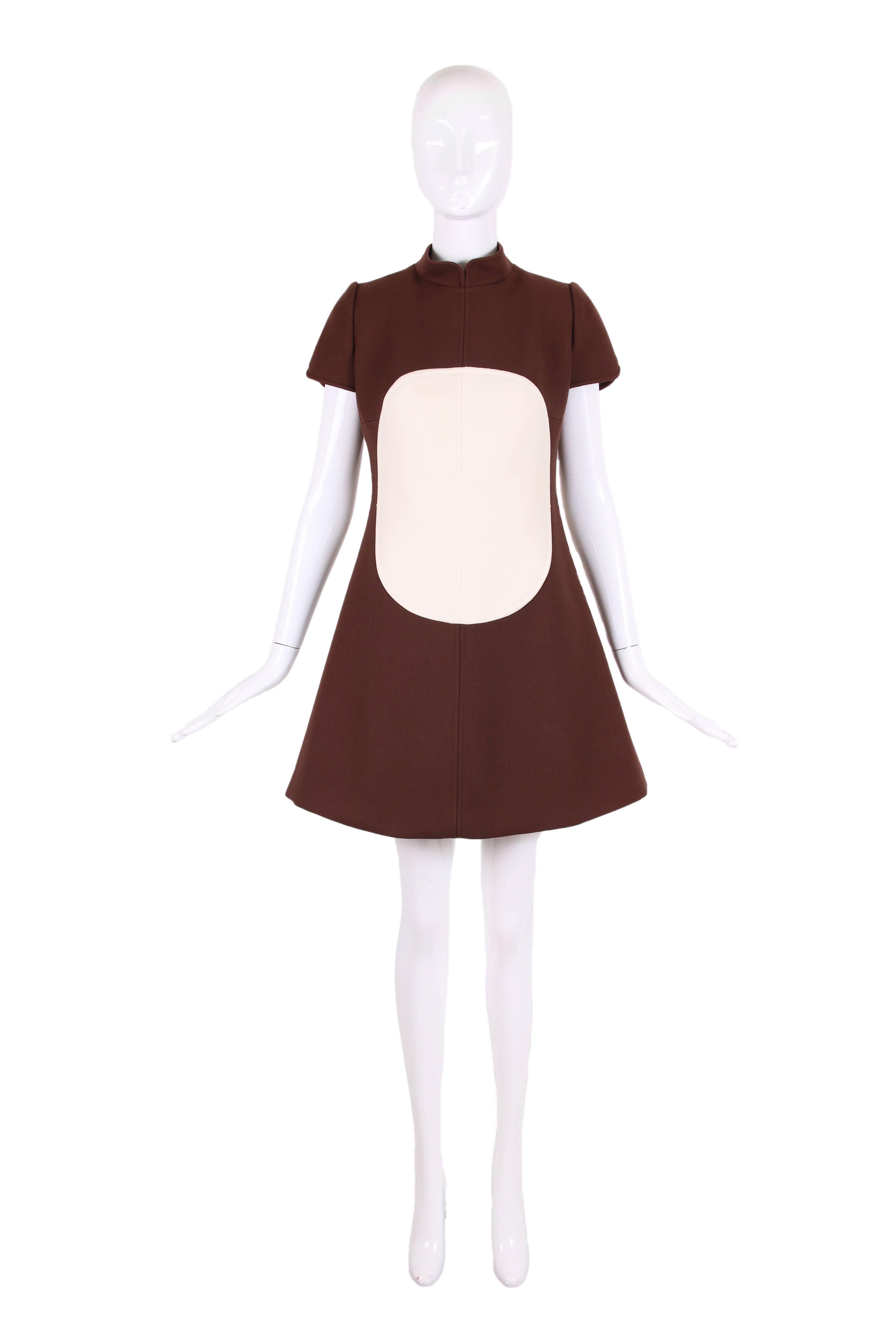 1960's Courreges for I. Magnin brown wool A-line mini dress w/cap sleeves, stand collar and creme circle motif at front and back. Zipper closure up center back. In excellent condition with very minor yellowing at interior lining under sleeve. There