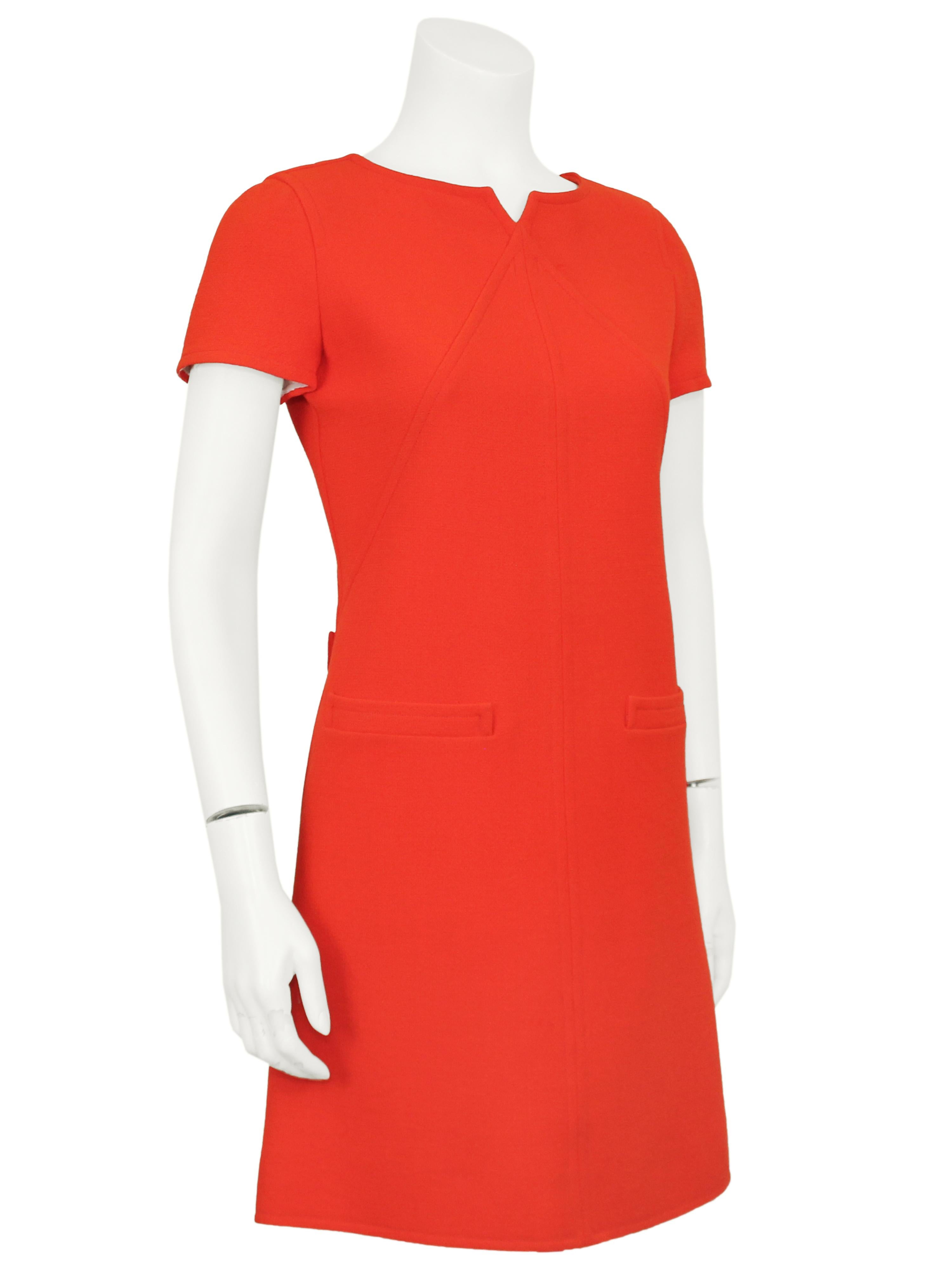 Un classico di Courreges con un tocco di novità: questo vestito a turni rosso/arancio è sempre di moda. Maniche corte con scollatura dentellata, pinces diagonali sul davanti e una cucitura al centro e due tasche finte sui fianchi. Ha una cerniera