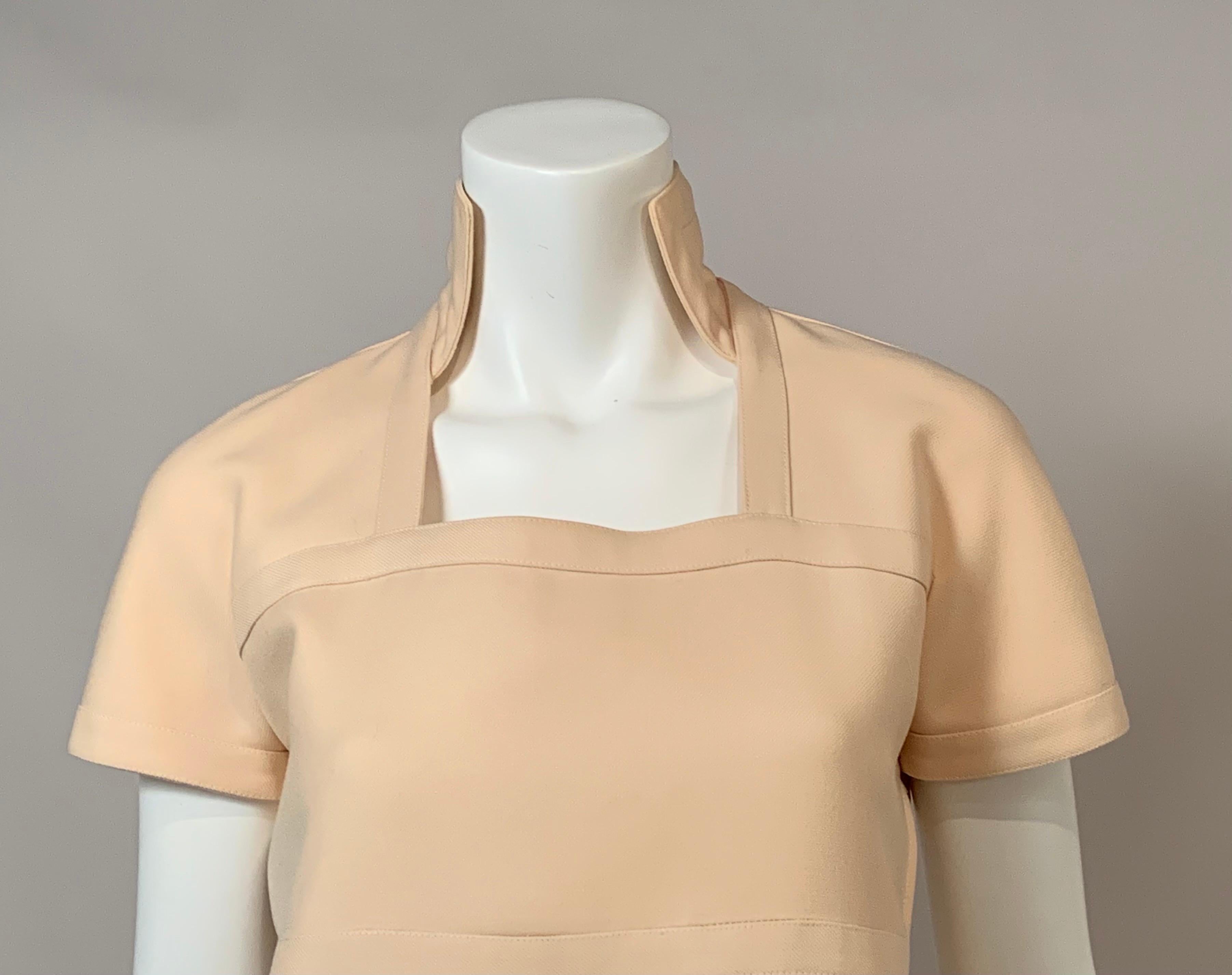 Andre Courreges designed this dress in the late 1960's using a Winter White wool.  It has a face framing stand up collar and four horizontal bands made from the same fabric.  These bands also edge the collar, the sleeves and the side openings at the