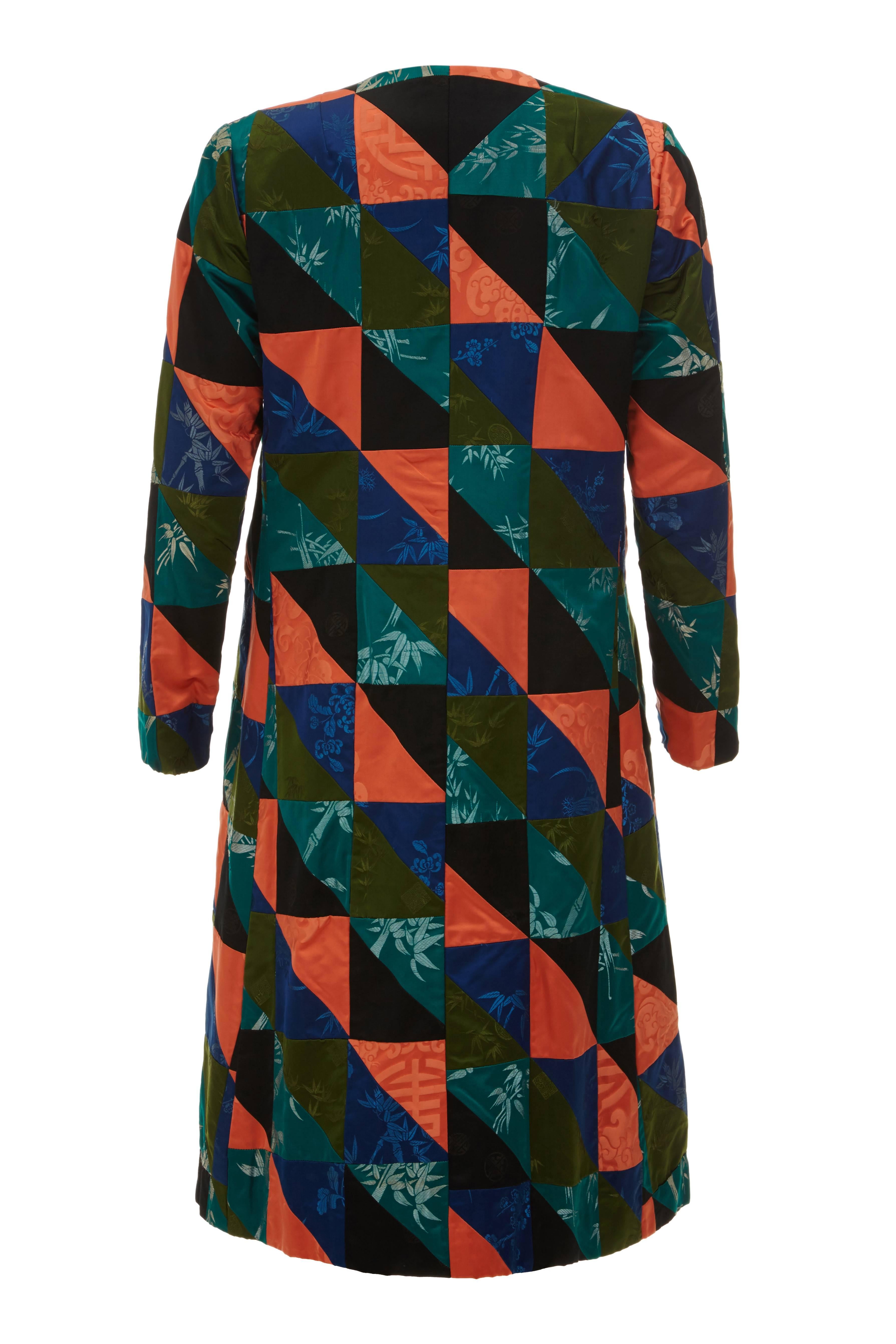 Stunning and original vintage 1960s A-line patchwork Chinese silk coat. This duster coat is very unusual and is entirely made from a repeat pattern of imported Chinese silk fabrics in black, greens, blue and orange.  The silk jacquard fabrics each