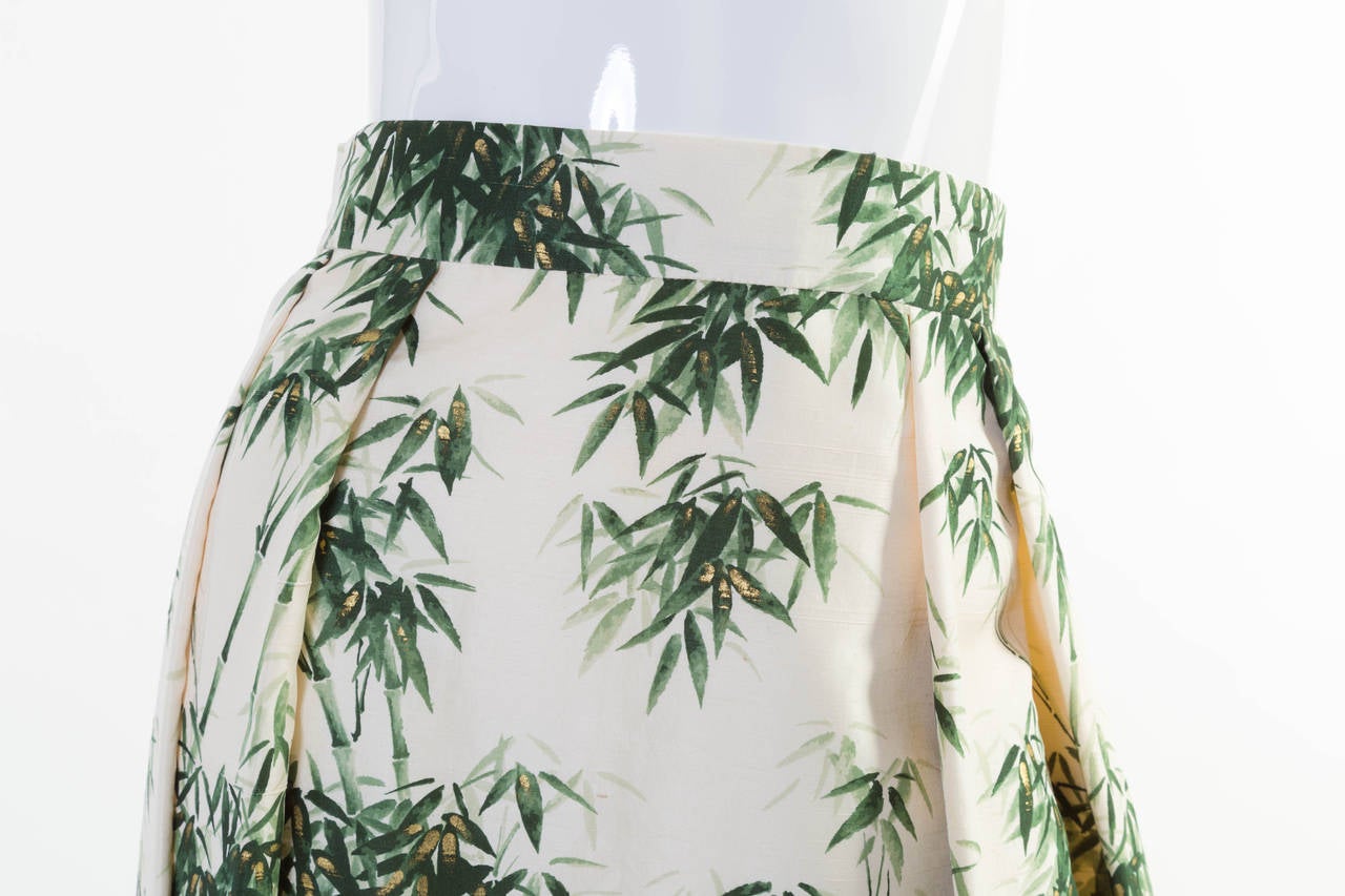 The designer of this skirt is unknown, but that makes it no less spectacular. Featuring an absolutely gorgeous bamboo and leaf print in rich green hues on ivory silk dupioni, the custom-made piece is striking and incredibly unique. The textile slubs