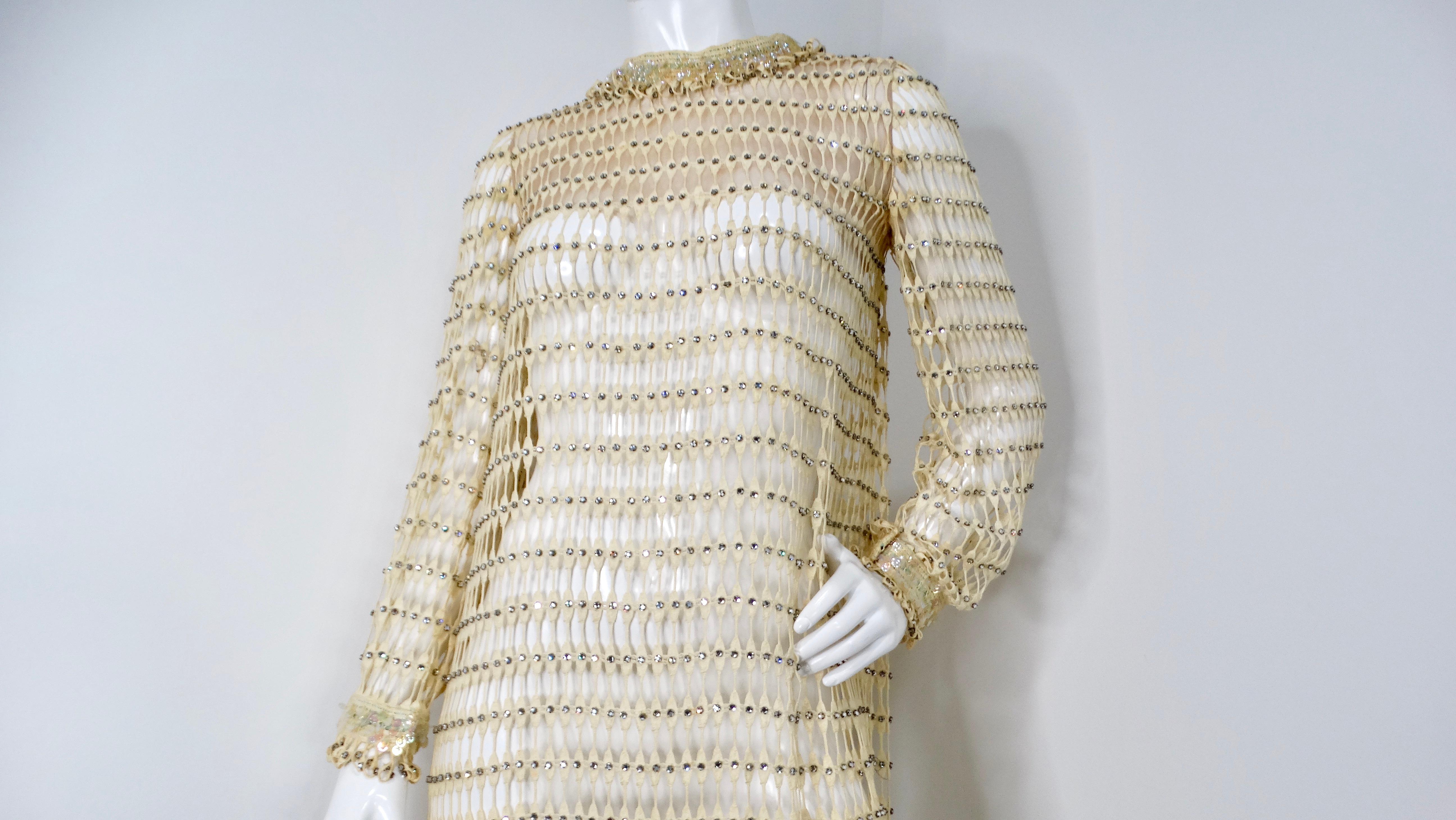 This stunning 1960s Crochet Rhinestone Cream & Iridescent Long-Sleeve Maxi Dress is a true vintage gem that encapsulates the bohemian elegance of the era. Crafted from delicate, see-through cream crochet, this exquisite dress features a cascading