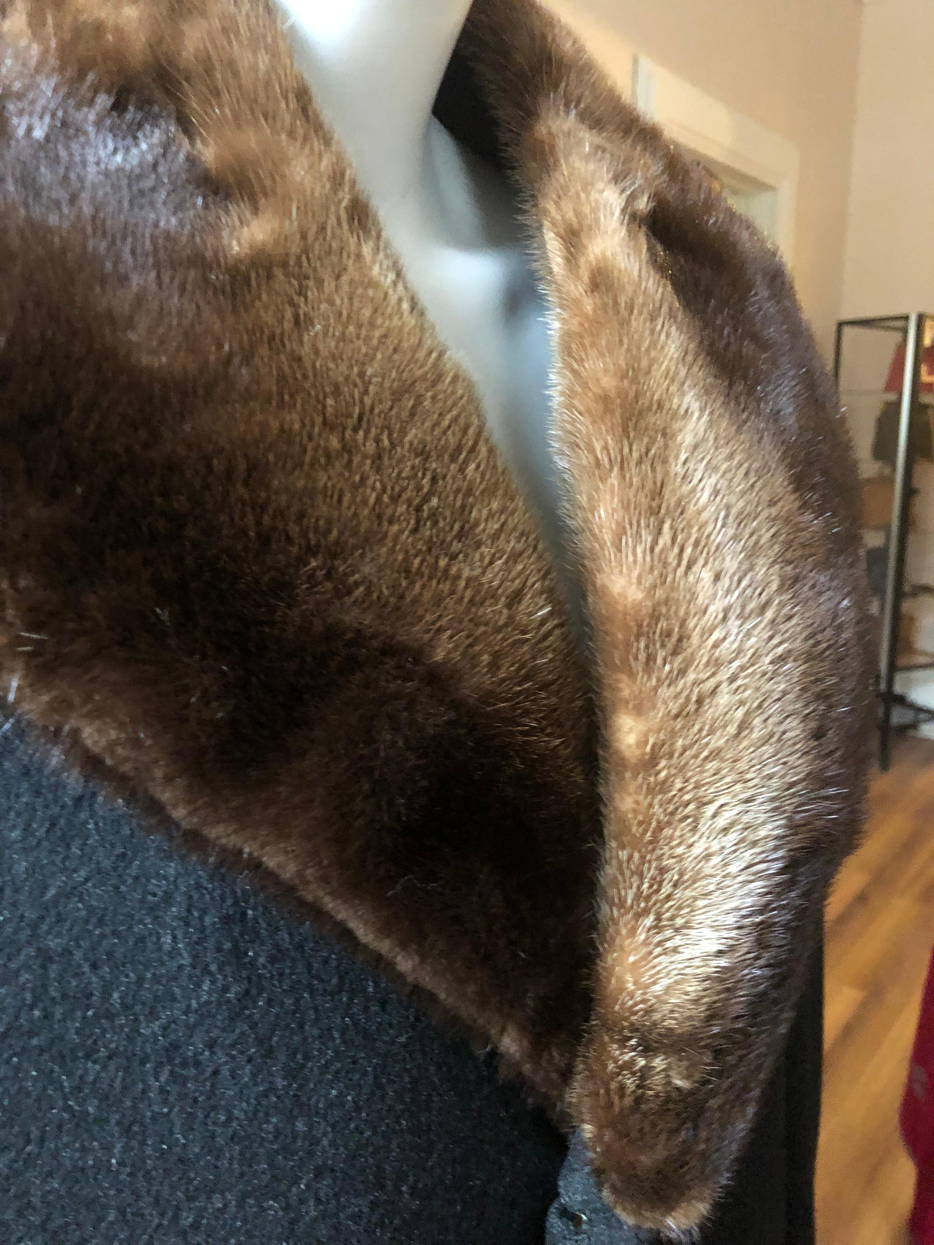 This 1960s Cashmere coat was loomed in Scotland and is in fantastic shape. There are two half built in cuffs with button; two front flap pockets; two inside pockets, a back centre vent; and a dark brown mink collar. The coat was tailored by Freedman