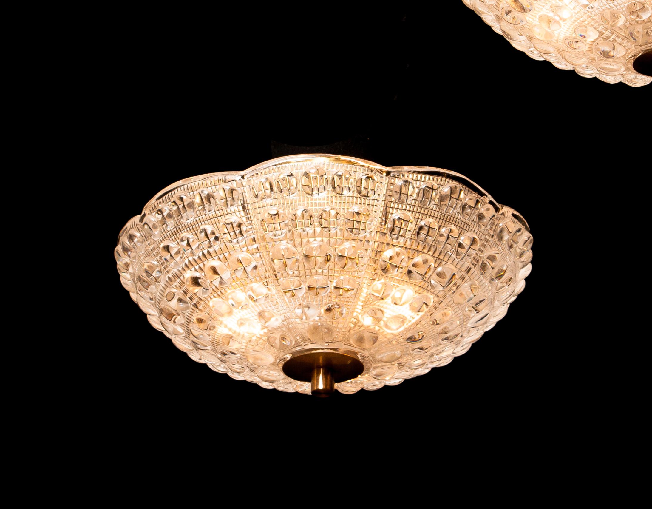 Beautiful ceiling light designed by Carl Fagerlund for Orrefors, Sweden.
This pendant is made of crystal glass and brass.
It is in a wonderful working condition.
Period 1960s.
Dimensions: H 20 cm, ø 36 cm.