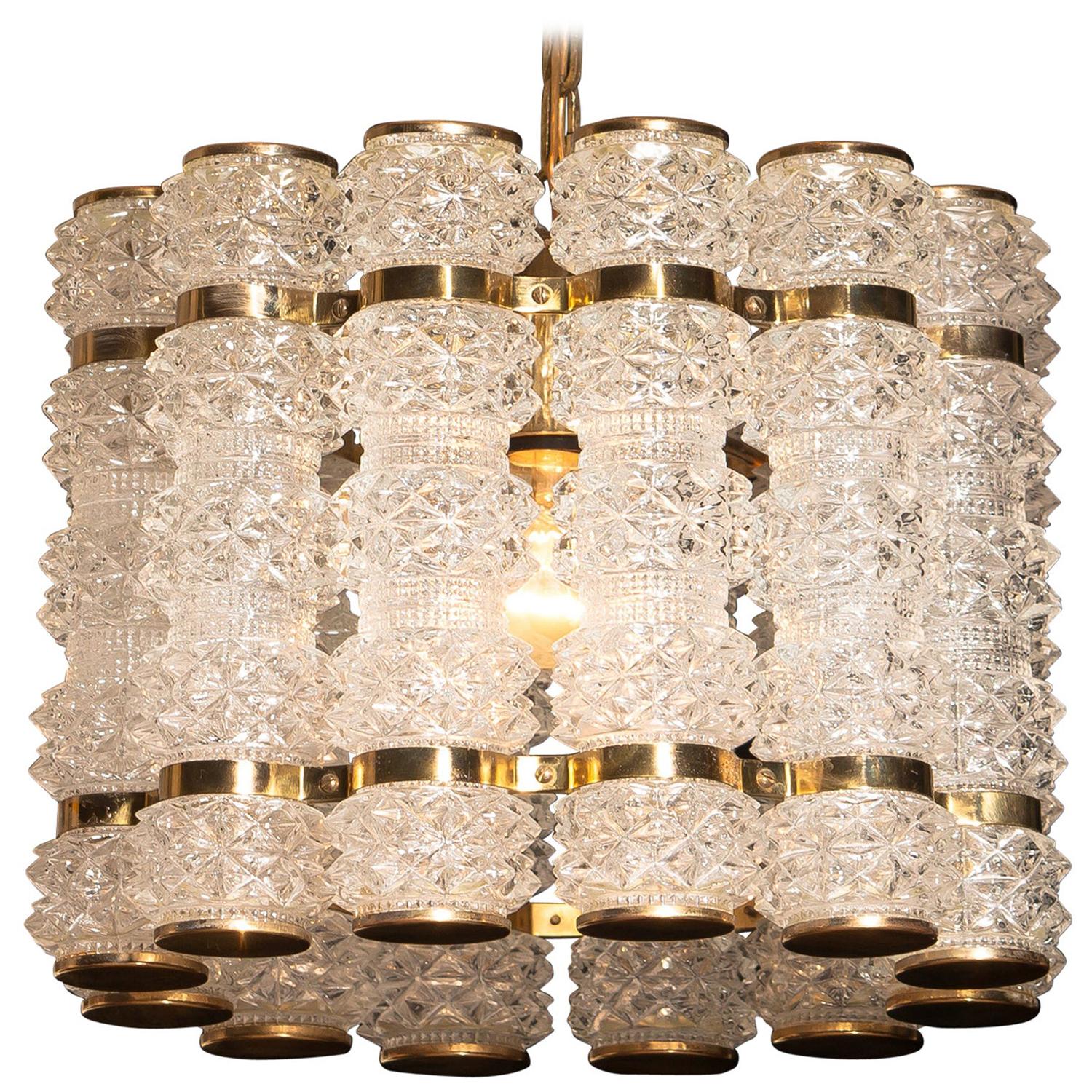 Beautiful and in perfect condition brass chandelier or pendant with twelve crystal cylinders.
Designed and manufactured in by Tyringe Konsthantverk, Sweden.
All crystal cylinders are made by Orrefors, Sweden.
Wired for 220 and 110 volts. Bulb