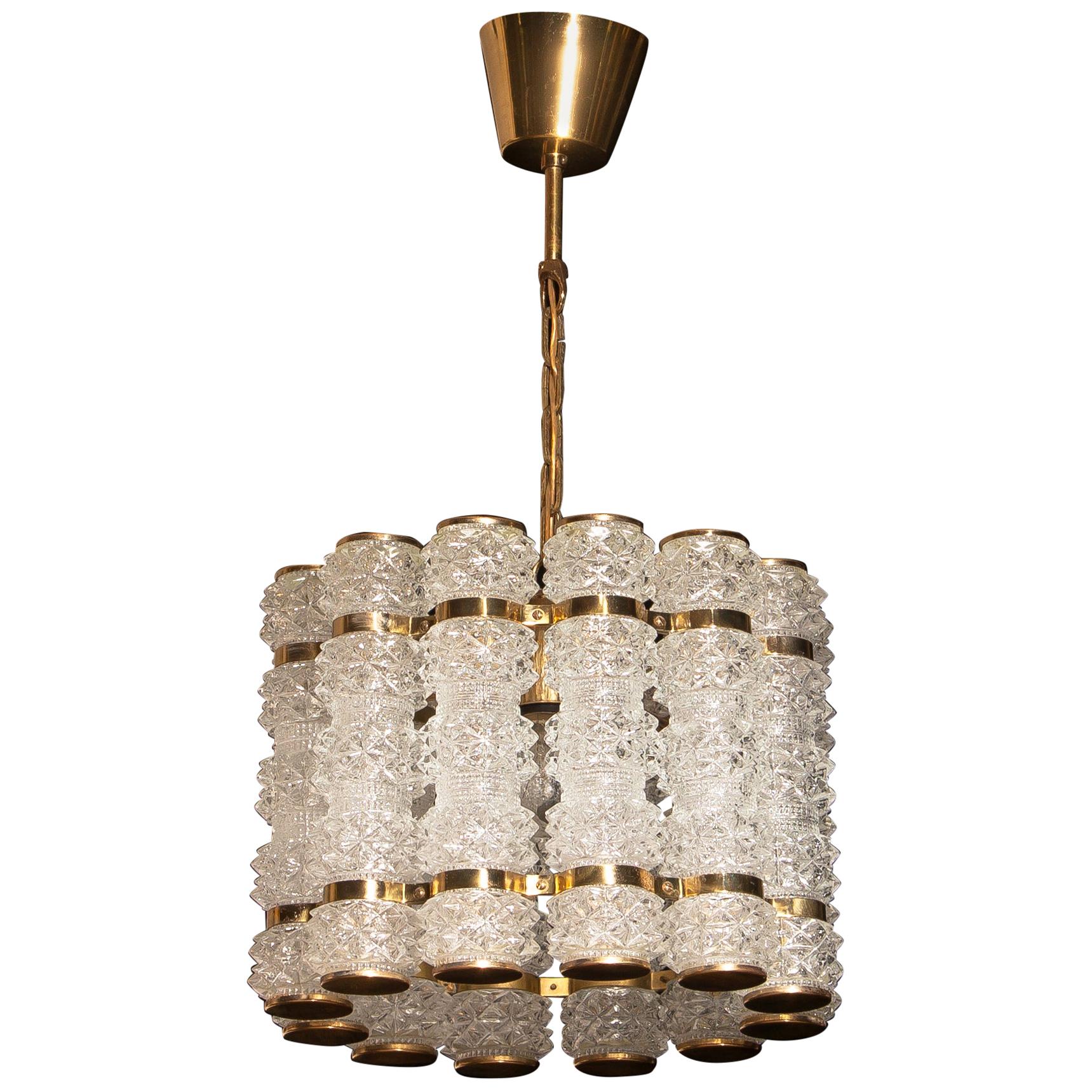 Beautiful and in perfect condition brass chandelier or pendant with twelve crystal cylinders.
Designed and manufactured in by Tyringe Konsthantverk, Sweden.
All crystal cylinders are made by Orrefors, Sweden.
Wired for 220 and 110 volts. Bulb