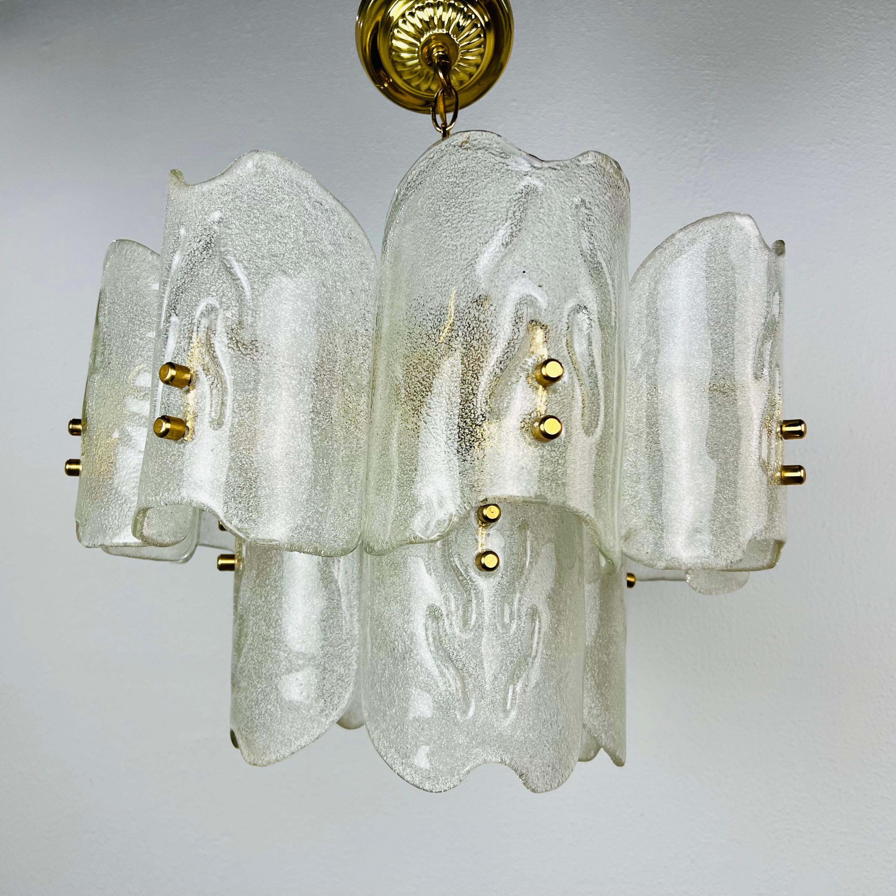 Stunning chandelier with twelve glass shades and brass fittings, produced in the 1960s by the iconic firm of Orrefors and designed by Carl Fagerlund. Beautifully carved frosted crystal glass shades on brass fittings. 4 bulbs.