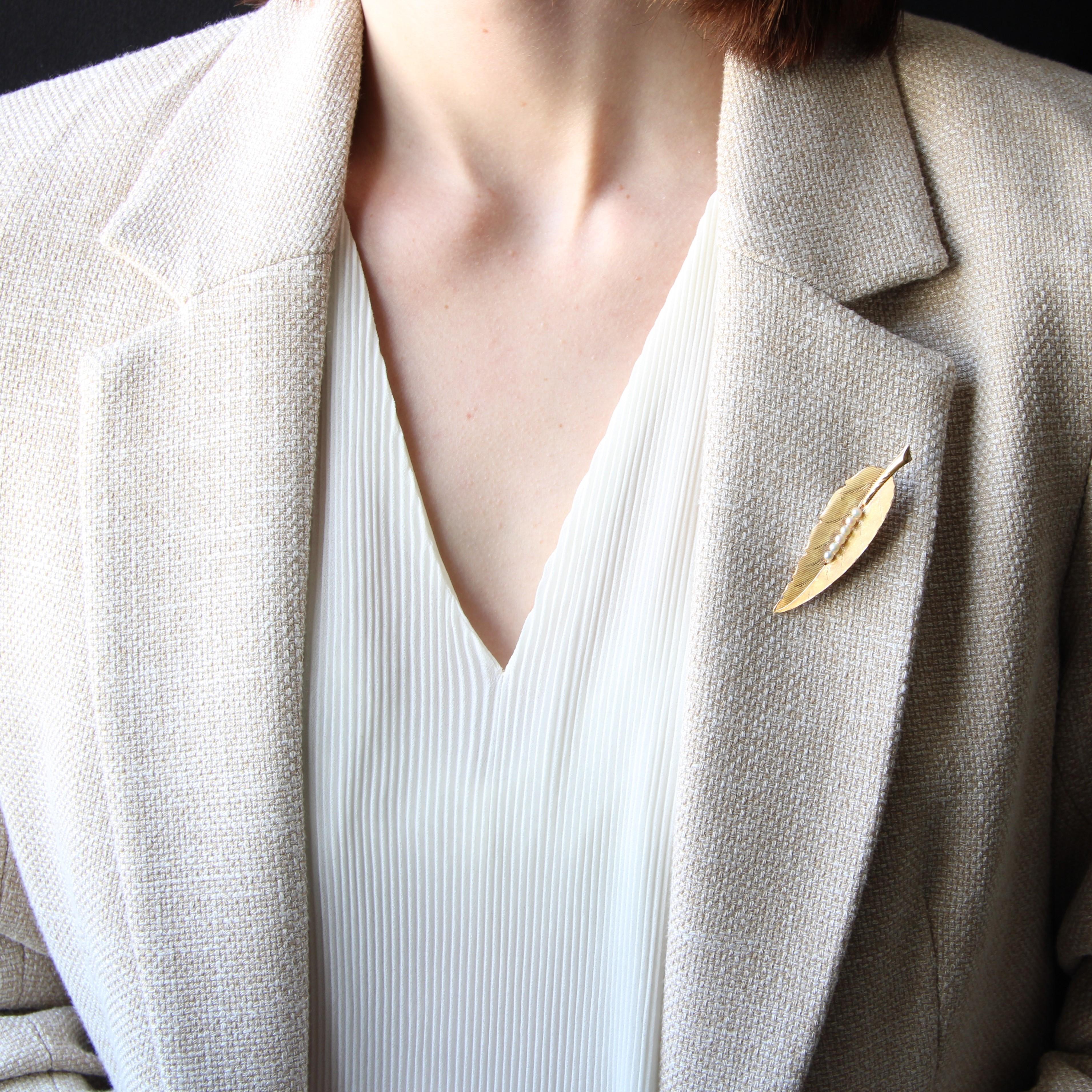 Brooch in 18 karat yellow gold.
Antique gold brooch, it represents a stylized feather of different finishes of material : brushed, chiseled, smooth and striated gold, which gives it a lot of realism and relief. The center of this retro brooch is