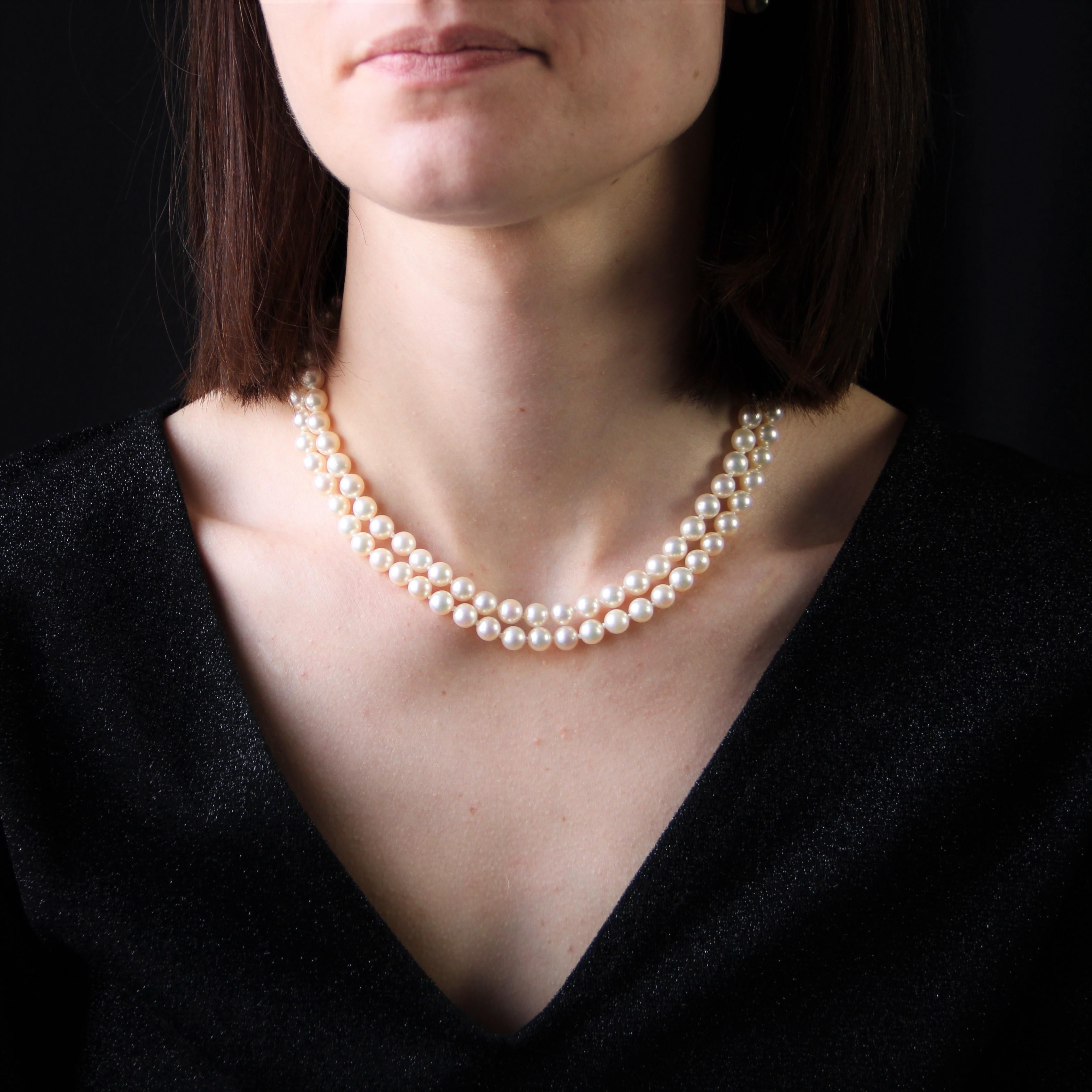 Retro necklace made up of 2 rows of pearly white cultured pearls in choker of identical size.
The clasp is in 14 karat yellow gold. It is openworked and decorated with 4 gold leaves and 5 cultured pearls. It is ratchet with safety 