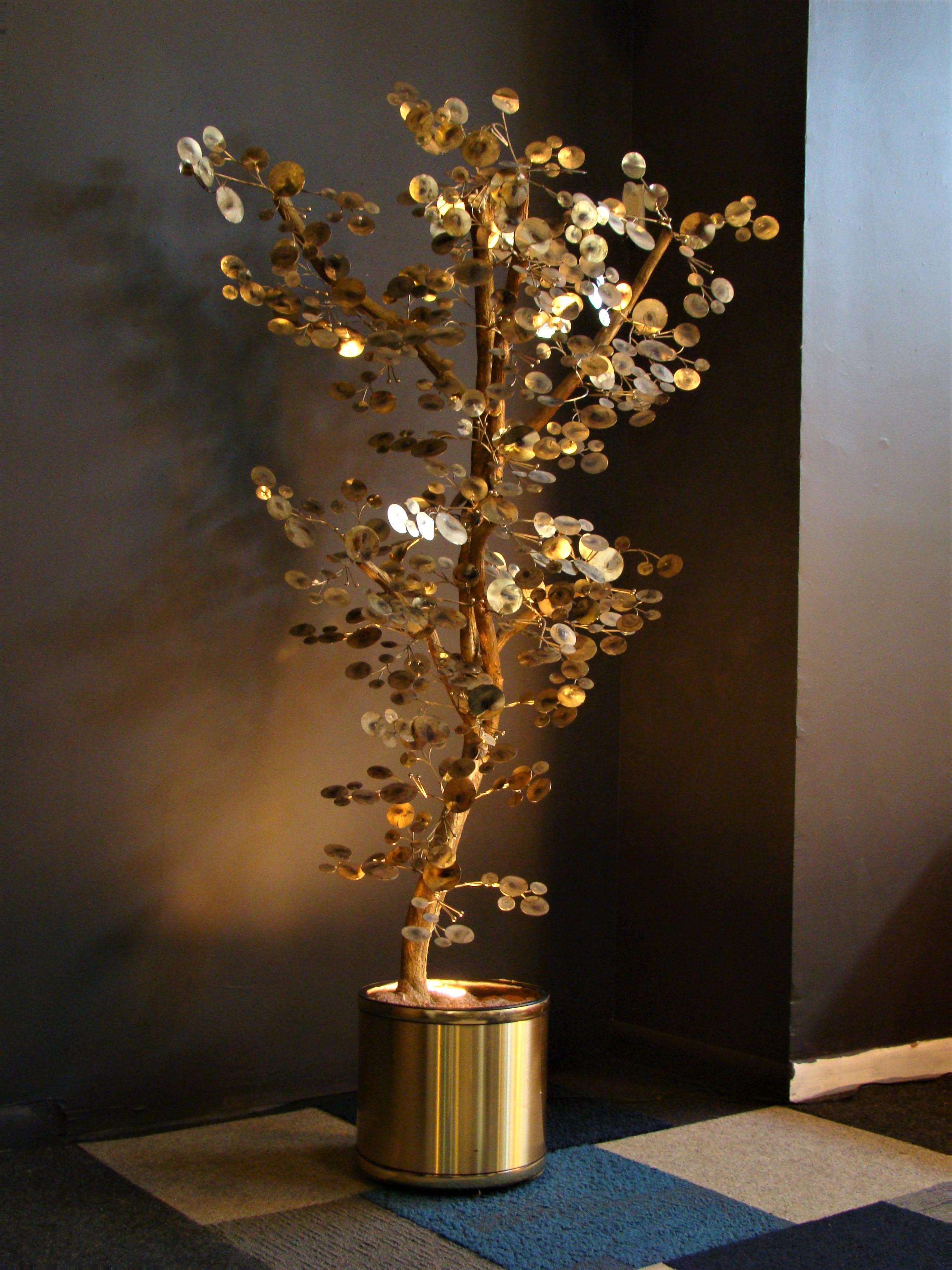 A substantial tree sculpture from the late 1960s, constructed from a natural tree branch embellished with gold patinated metal leaves, the sculpture is part of the 