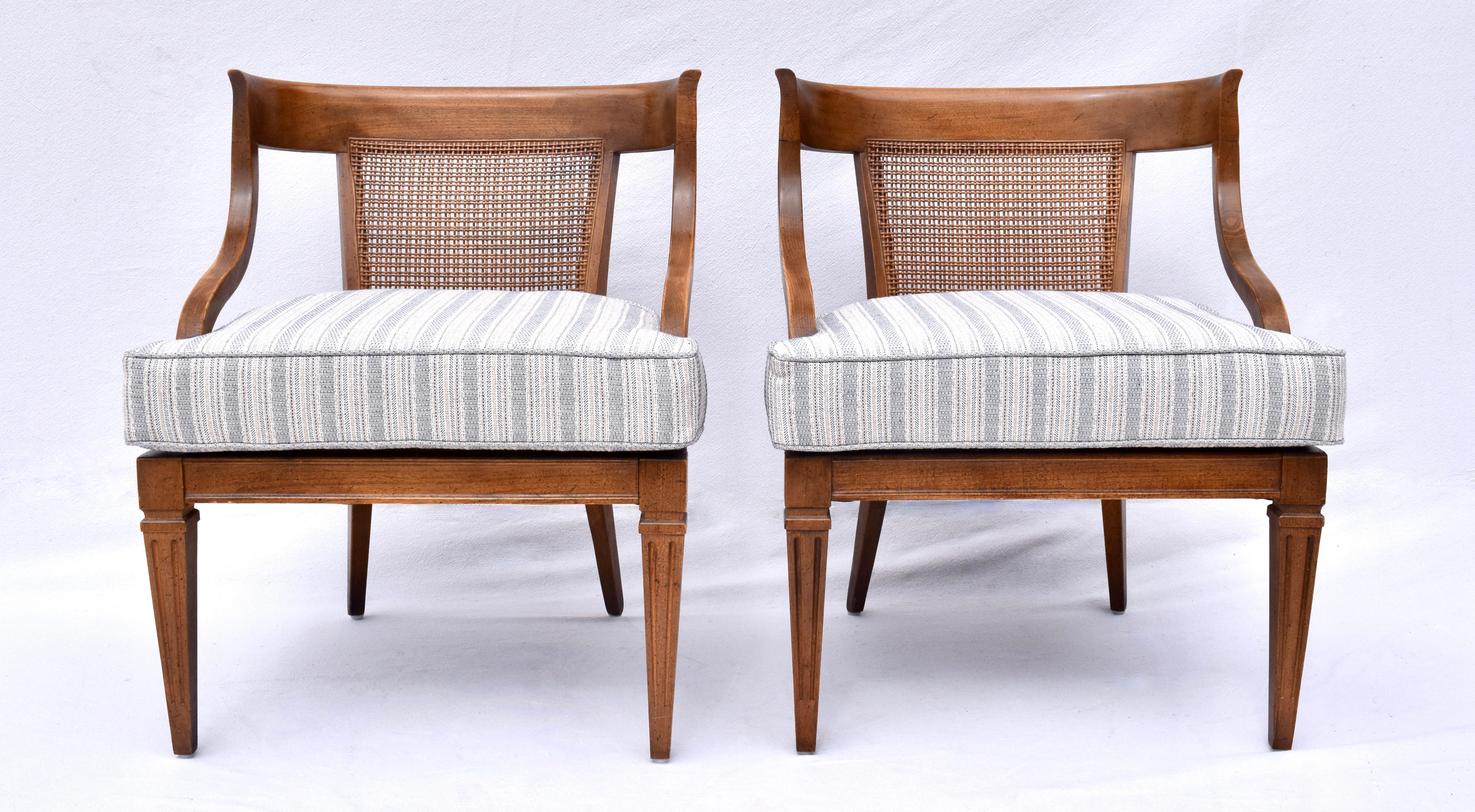 A pair of Mid century modern cane back chairs boasting an interesting mix of Regency, Empire &  mid 20th C. Modern design elements. Features include cradling comfort in the curved walnut backs, perfect original caning with new custom cushions &