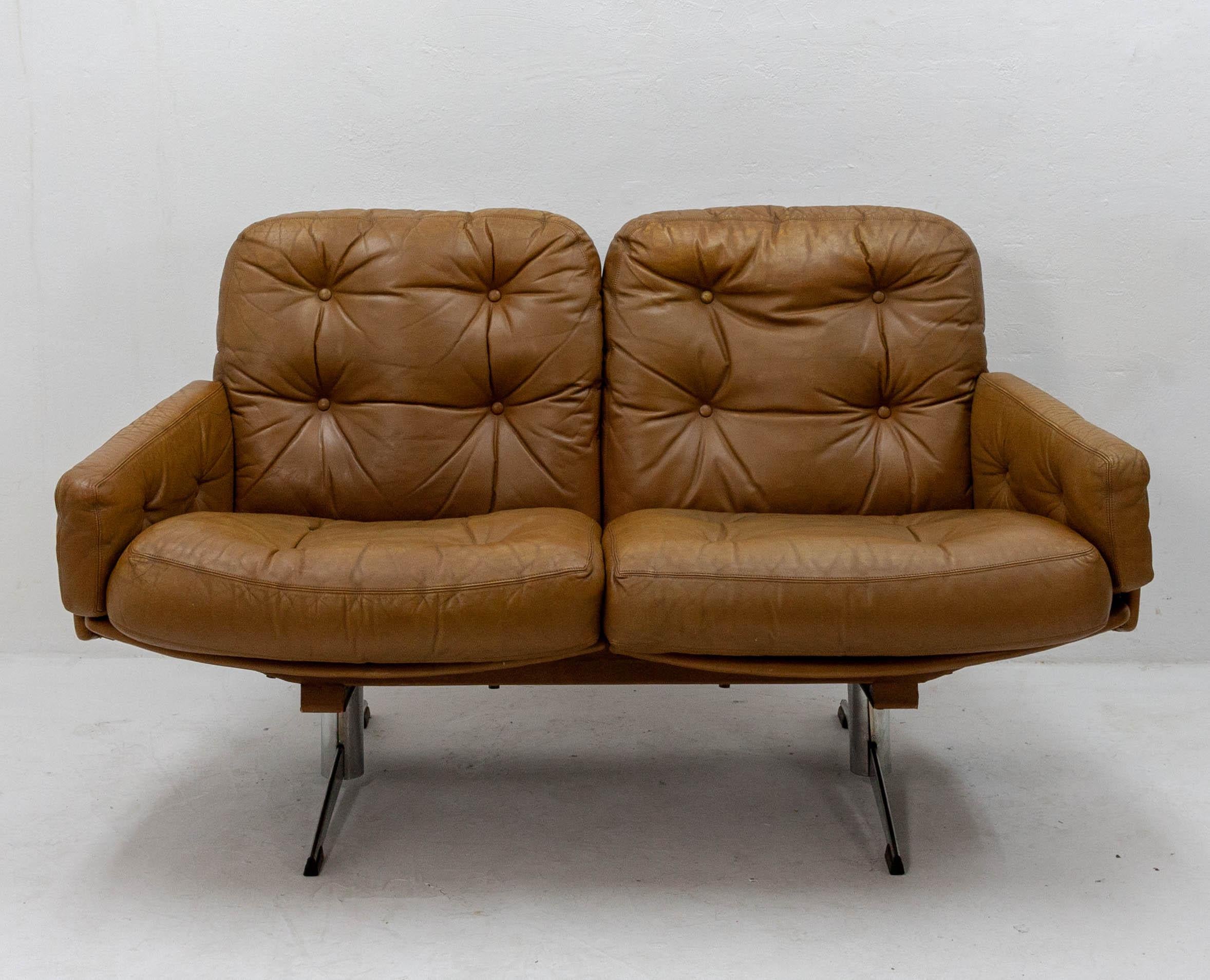 Comfortable and stylish leather loveseat featuring curved armrests and chrome feet. Caramel leather showing some patina, Italy, 1960s.