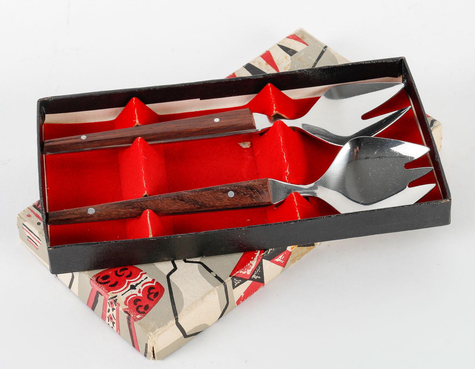 1960s cutlery sets.

Two pieces of 1960s cutlery in a metal and wood box, perfect for a baby.  
H: 1.5cm, W: 16cm, D: 9cm