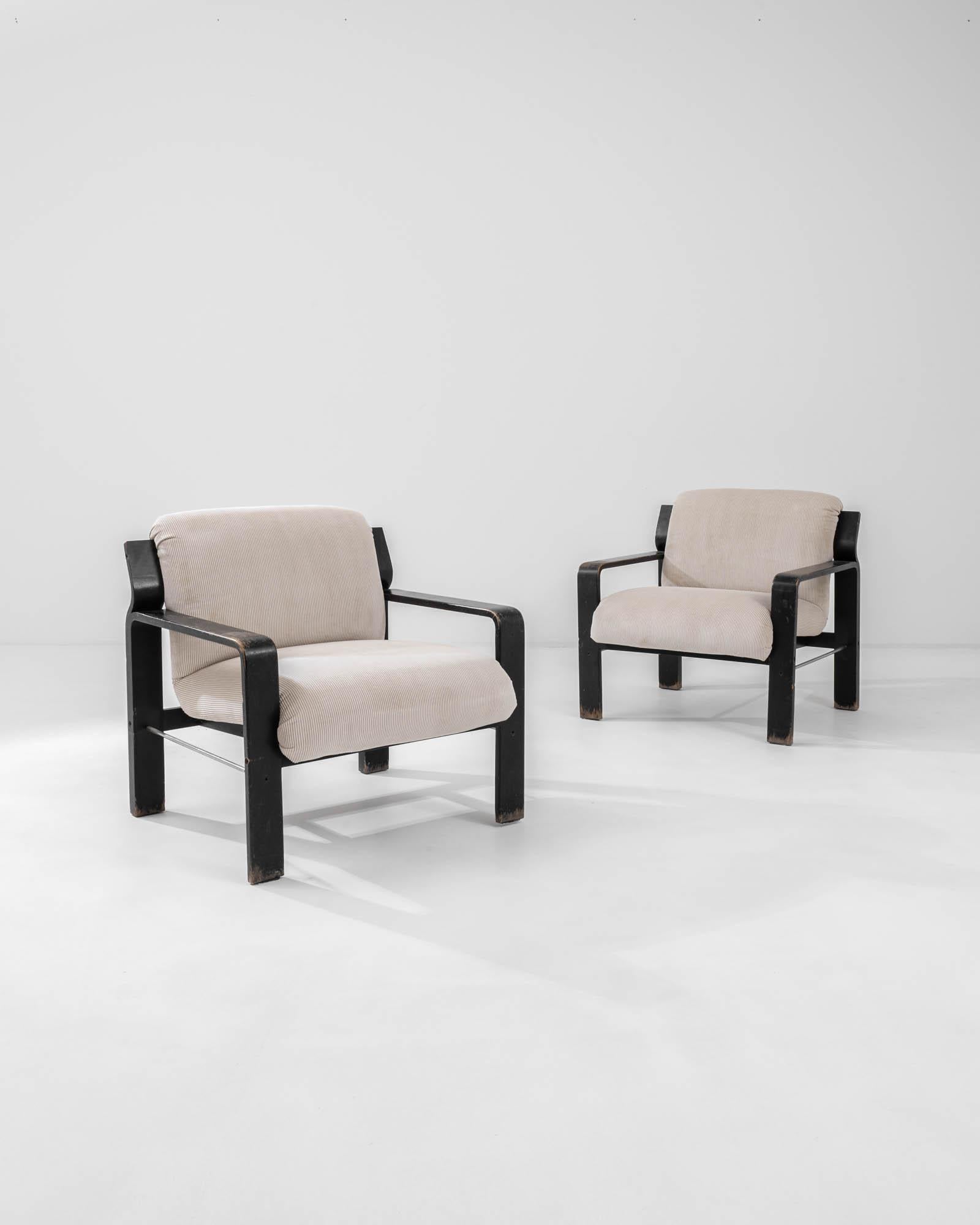 Effortlessly combining style and comfort, this pair of Mid Century Modern armchairs are a covetable find. Produced in the 1960s in the former Czechoslovakia, the design is attributed to Ludvik Volak, an architect and furniture designer known for his