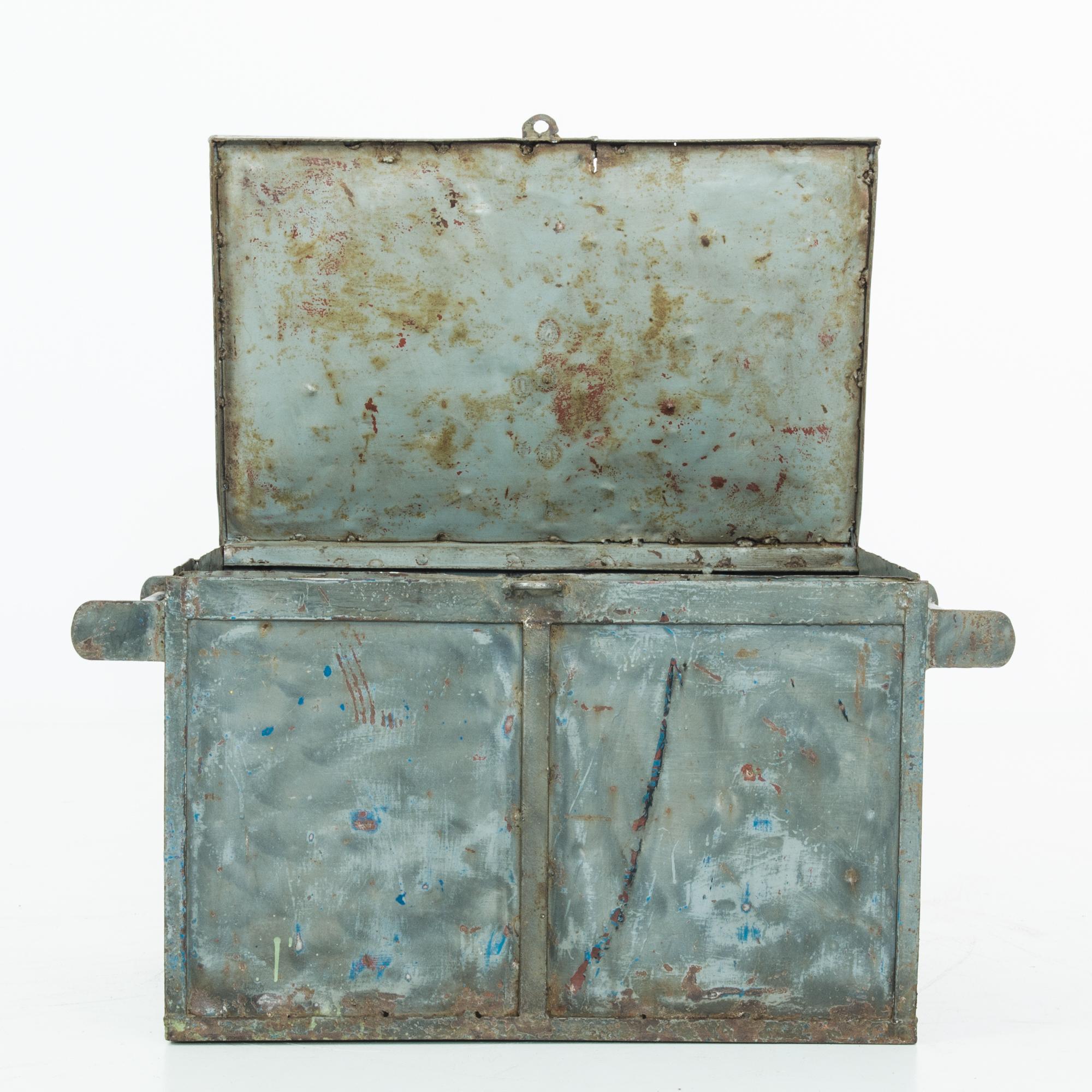 This 1960s Czech Metal Trunk is a true testament to the era's craftsmanship and utilitarian design. The trunk's robust metal construction speaks of durability, while its weathered blue patina and visible signs of wear add an authentic industrial