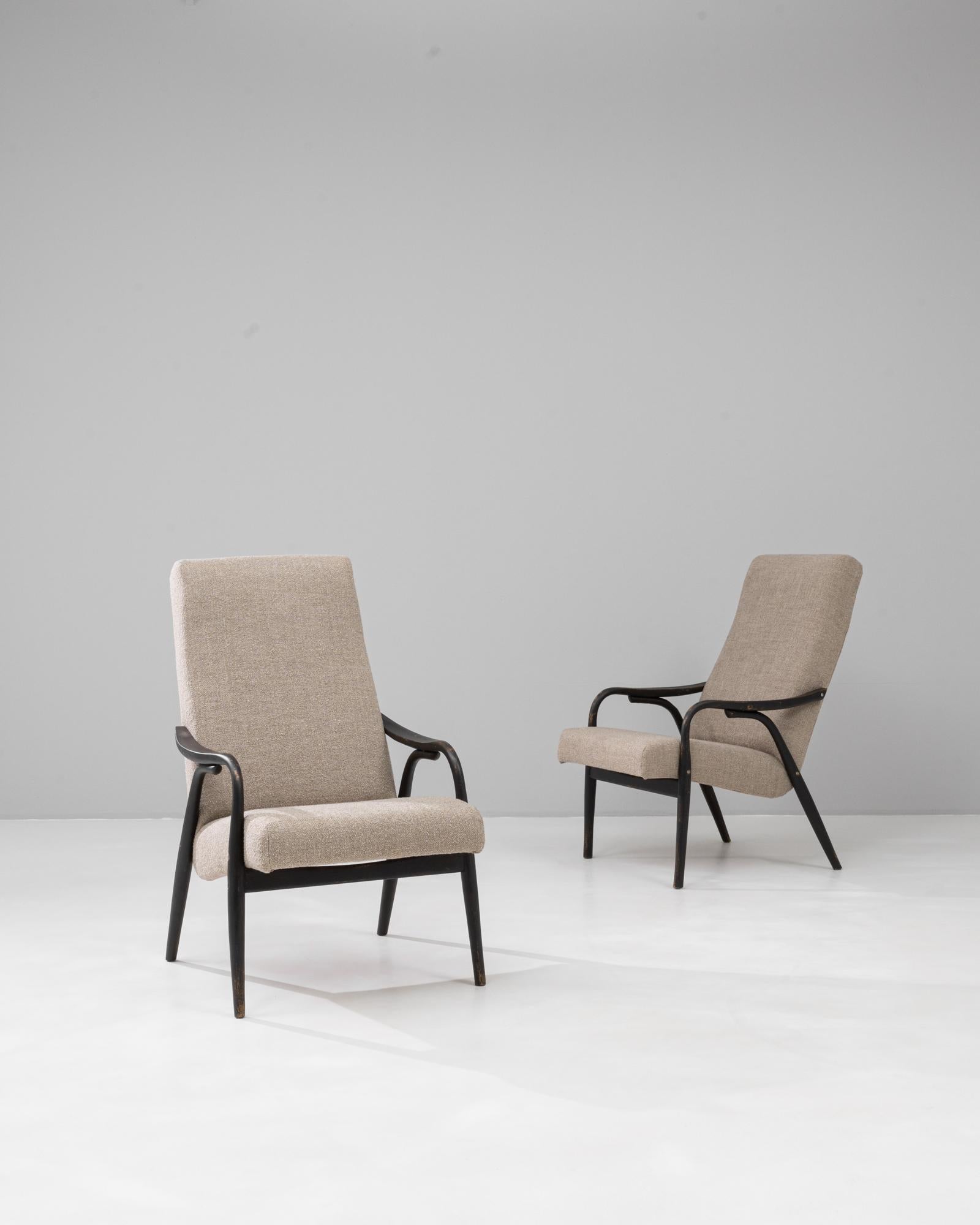 Cette paire de fauteuils rembourrés tchèque des années 1960 par TON reflète l'élégance épurée et le savoir-faire du design moderne du milieu du siècle. Dotées d'un cadre en bois teinté foncé légèrement incurvé, les chaises équilibrent l'intégrité