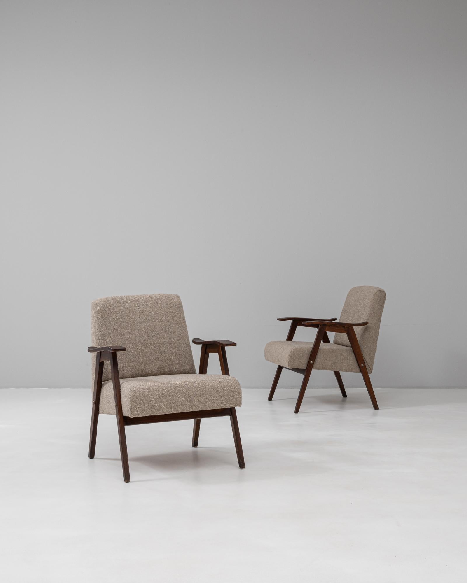 Questa coppia di poltrone imbottite ceche degli anni '60 riflette l'estetica pulita e funzionale del design di metà secolo proveniente dall'Europa centrale. Ogni sedia presenta una solida struttura in legno con gambe angolari e braccioli