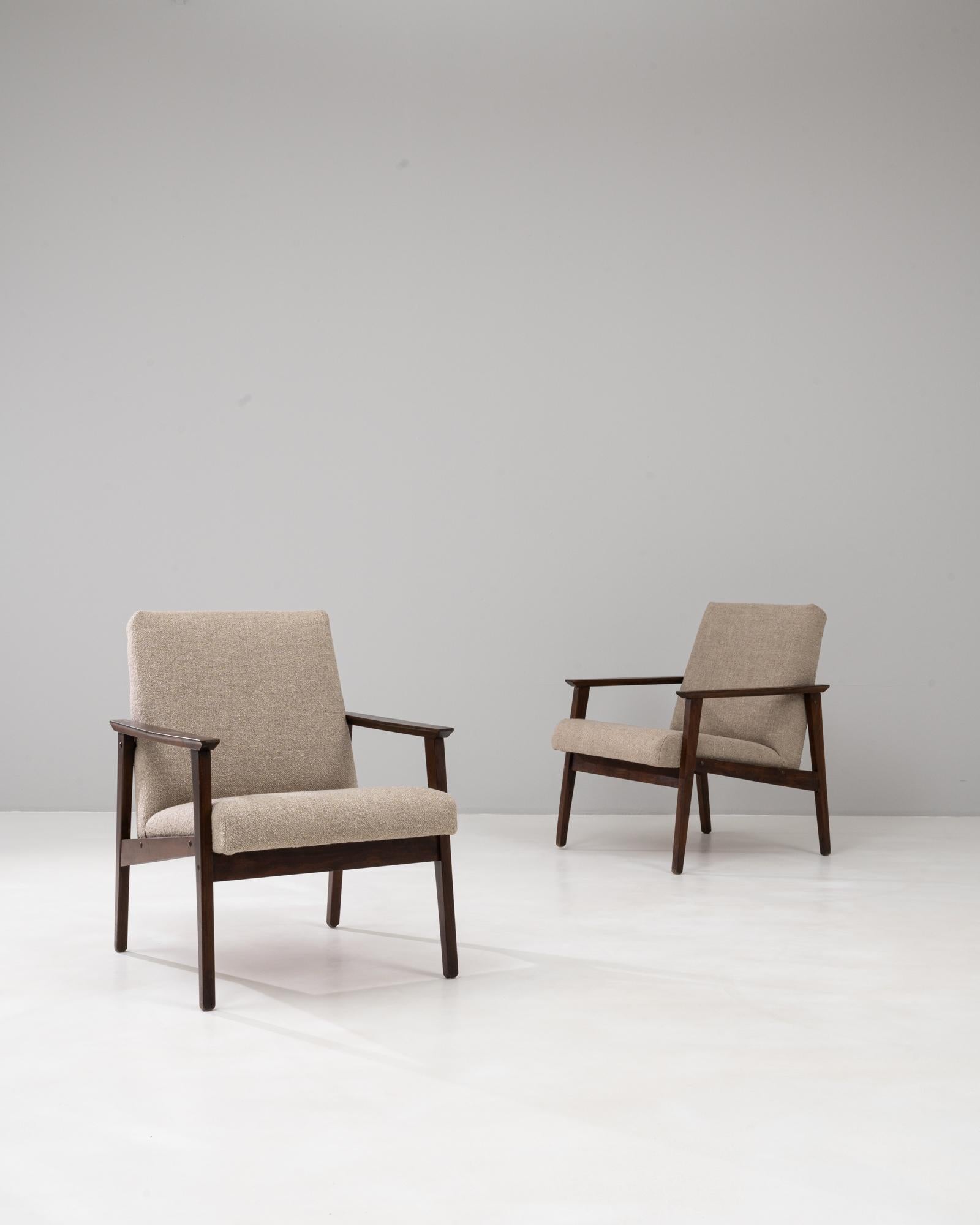 Questa coppia di poltrone imbottite ceche degli anni '60 riflette la raffinata semplicità e funzionalità del design di metà secolo. Costruite con telai in legno puliti e angolari in tinta scura, le sedie sottolineano sia la durata che lo stile. I