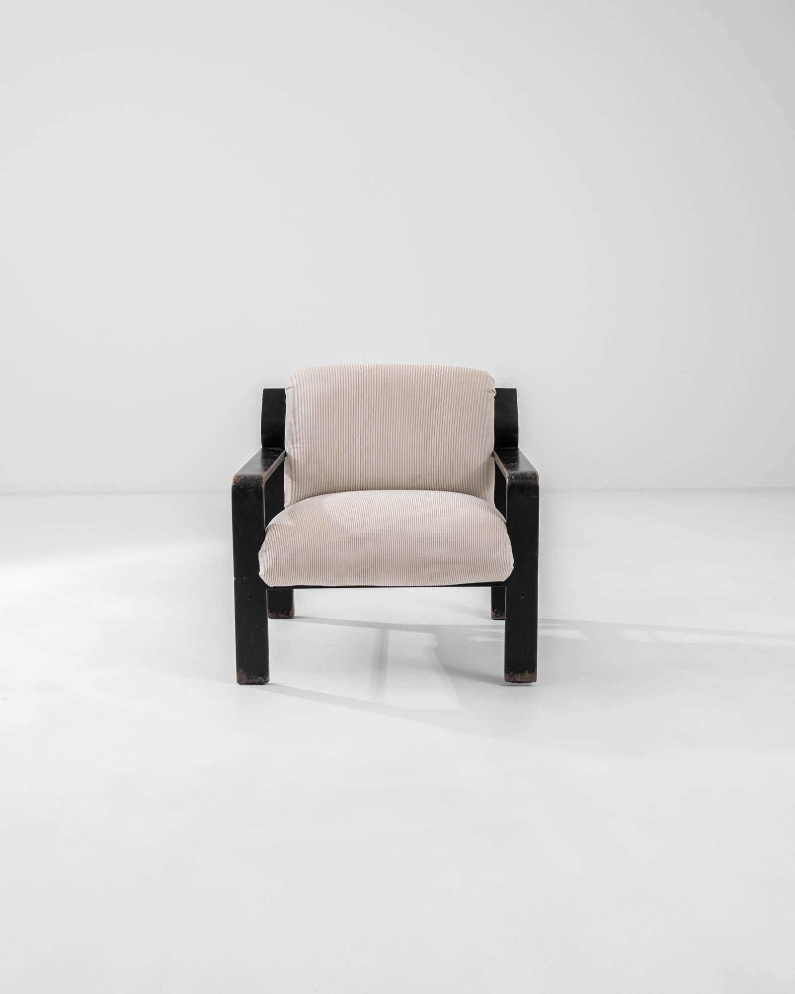 Cet excellent fauteuil tchèque moderne du milieu du siècle, conçu dans les années 1960, présente une élégante base en bois en forme d'équerre définie par des lignes nettes, ce qui renforce le dynamisme visuel. Un seul coussin, revêtu d'un velours