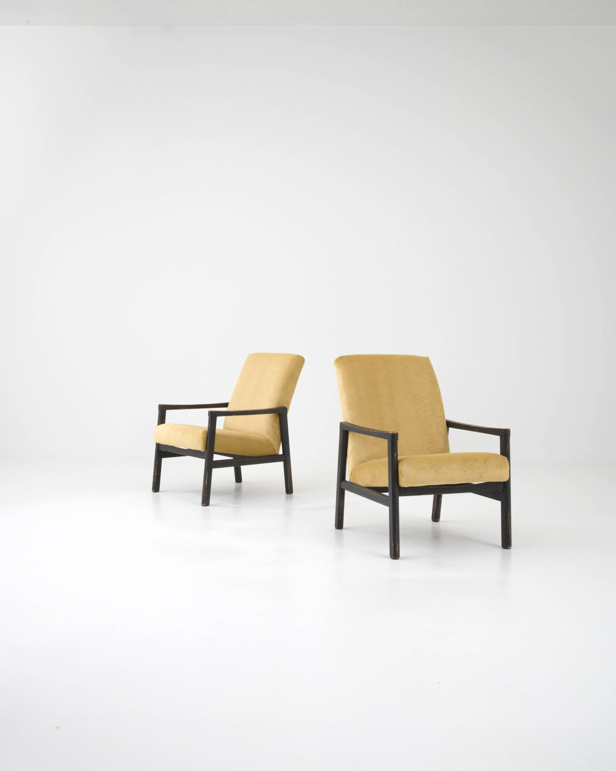 Light and stylish, this pair of Mid-Century armchairs showcase the sophistication of Central European Modernist design. Built in Czechia in the 1960s, the clean angles of the wooden frame creates an eye-catching profile. The cushioned seat is set at